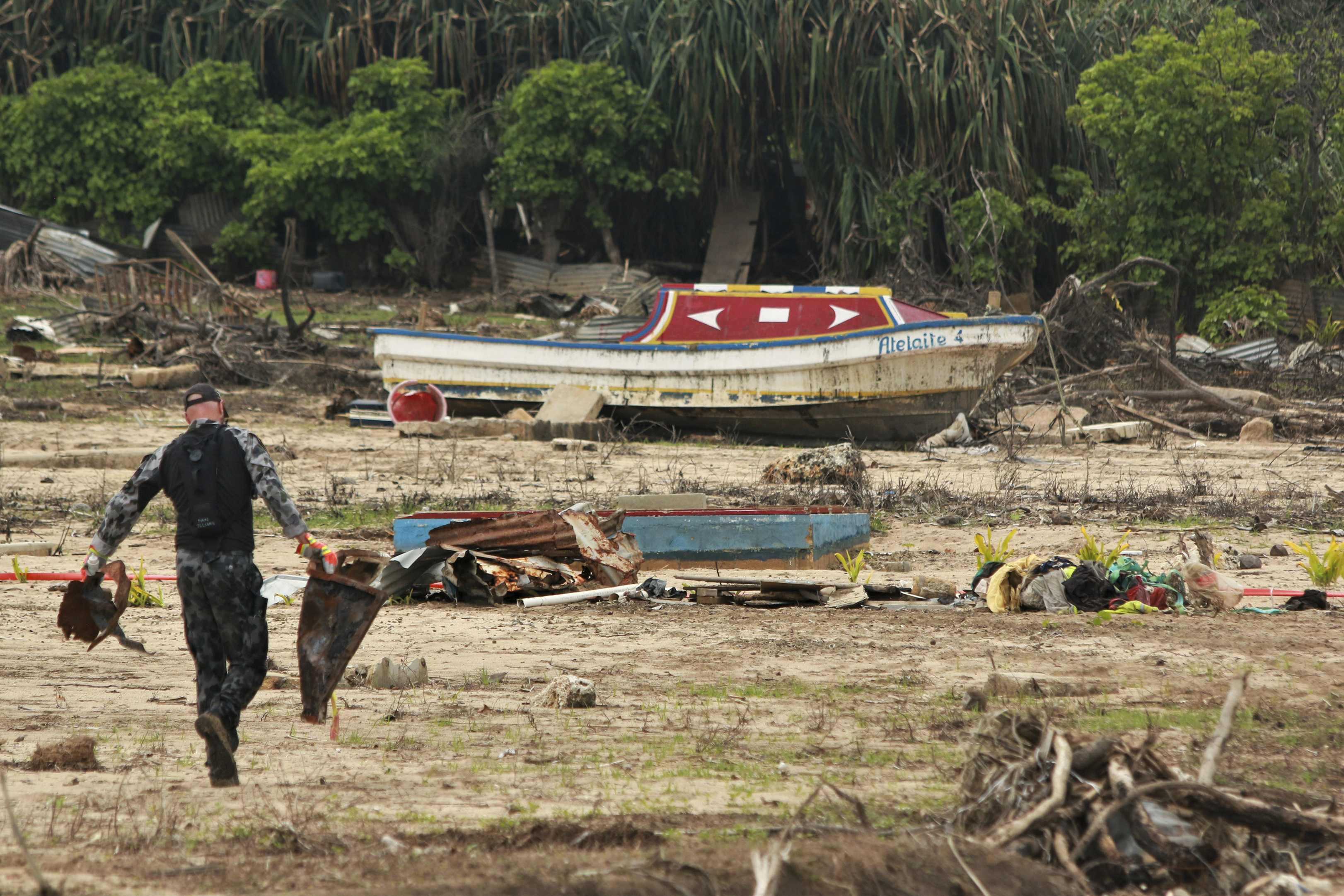 In this photo supplied by the Royal Australian Navy, a sailor from HMAS Supply clears debris on Nomuka Island, Tonga on Feb. 26, 2022. Three months on from a devastating volcano and tsunami in Tonga, the AP checks in on how the island nation is recovering. The bill from the tsunami is estimated at some $90 million and GDP is expected to fall by more than 7% this year. The cleanup has been hindered by an internet outage caused by the tsunami and the nations first outbreak of COVID-19. (LSCSO Rye 