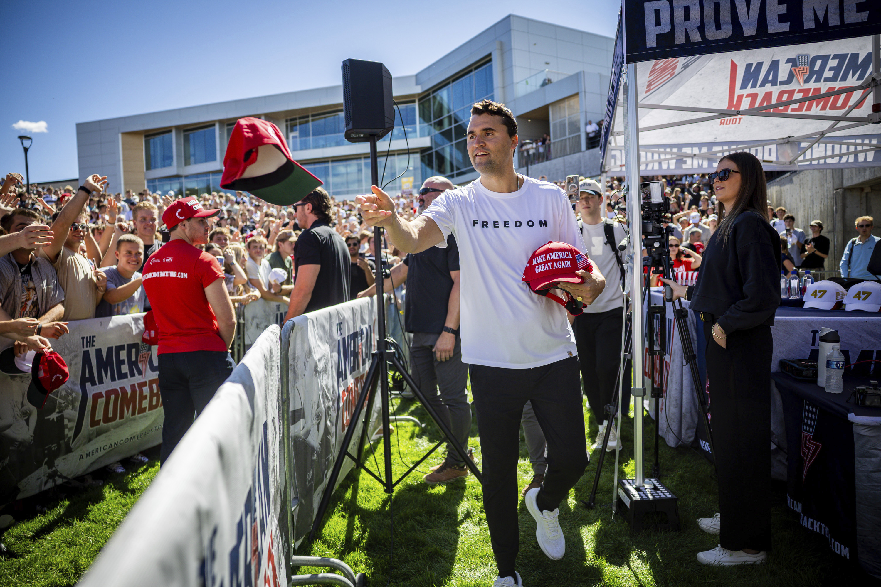 Charlie Kirk hands out hats before speaking at Utah Valley University in Orem, Utah, Wednesday, Sept. 10, 2025. (Tess Crowley/The Deseret News via AP)