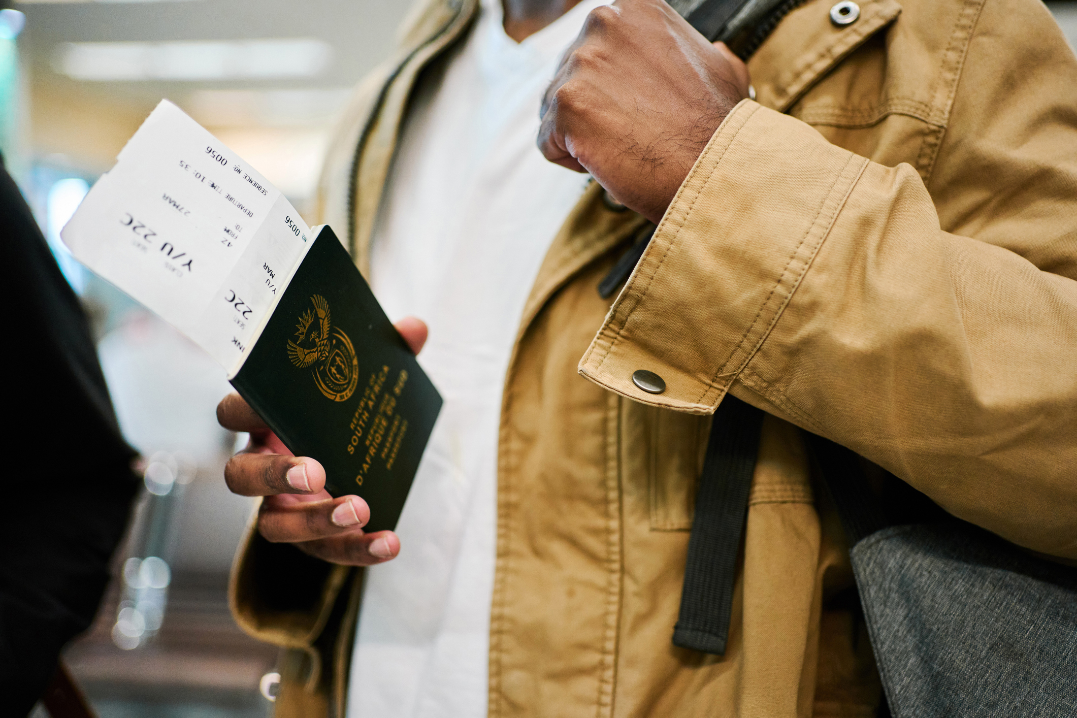 Close-up of male traveler on a vacation holding his passport and boarding pass at airport