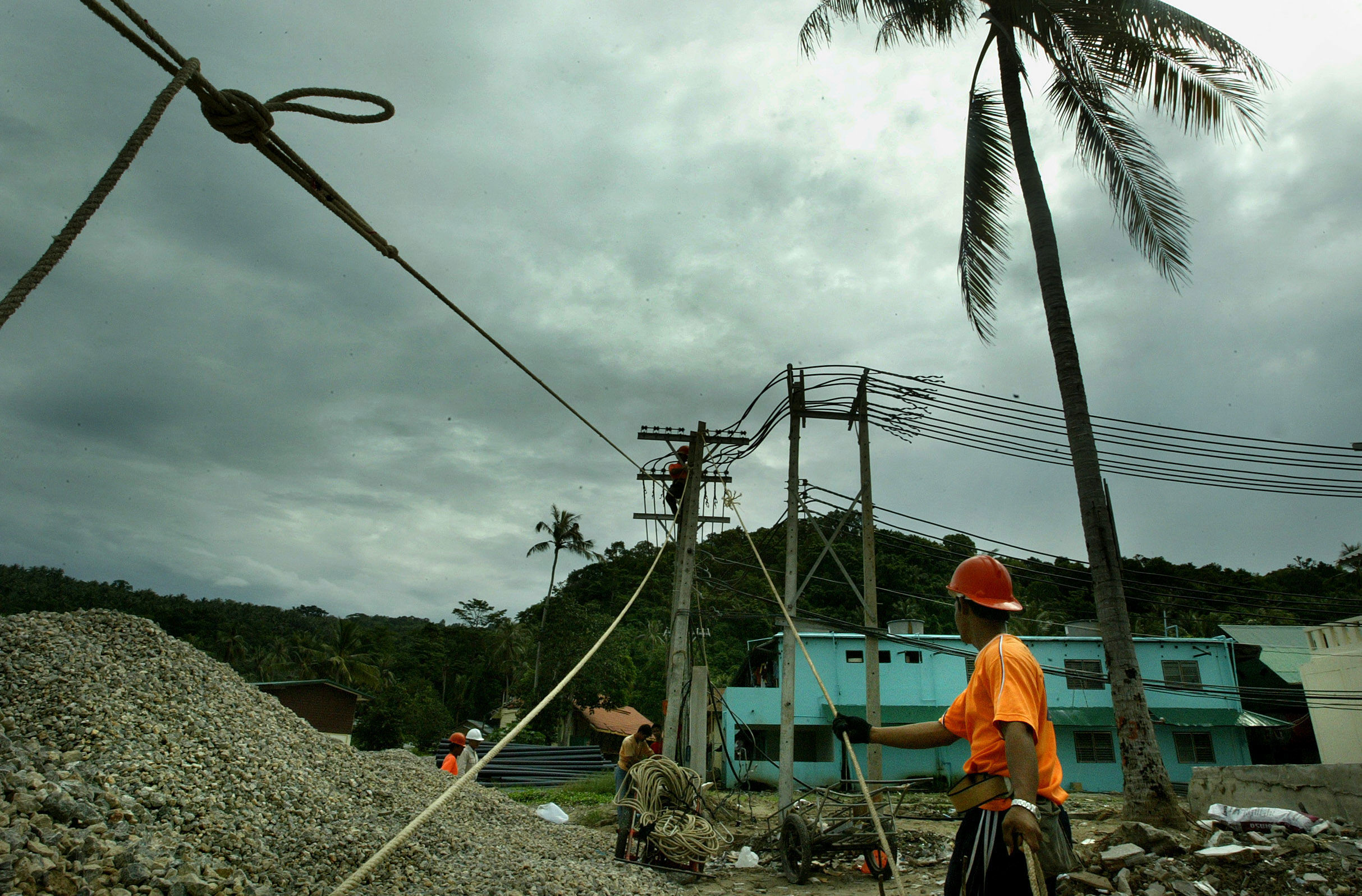 Thai constuction workers reinstall powerlines in the tsunami affected area of Phi Phi island. The island was one of the worst hit areas in Thailand by the 2004 Boxing Day tsunami.