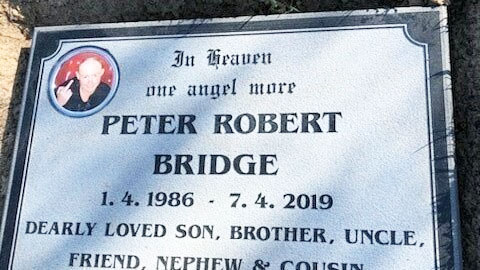 The headstone, with the photo of Peter Bridge sticking up his middle finger, which was removed.