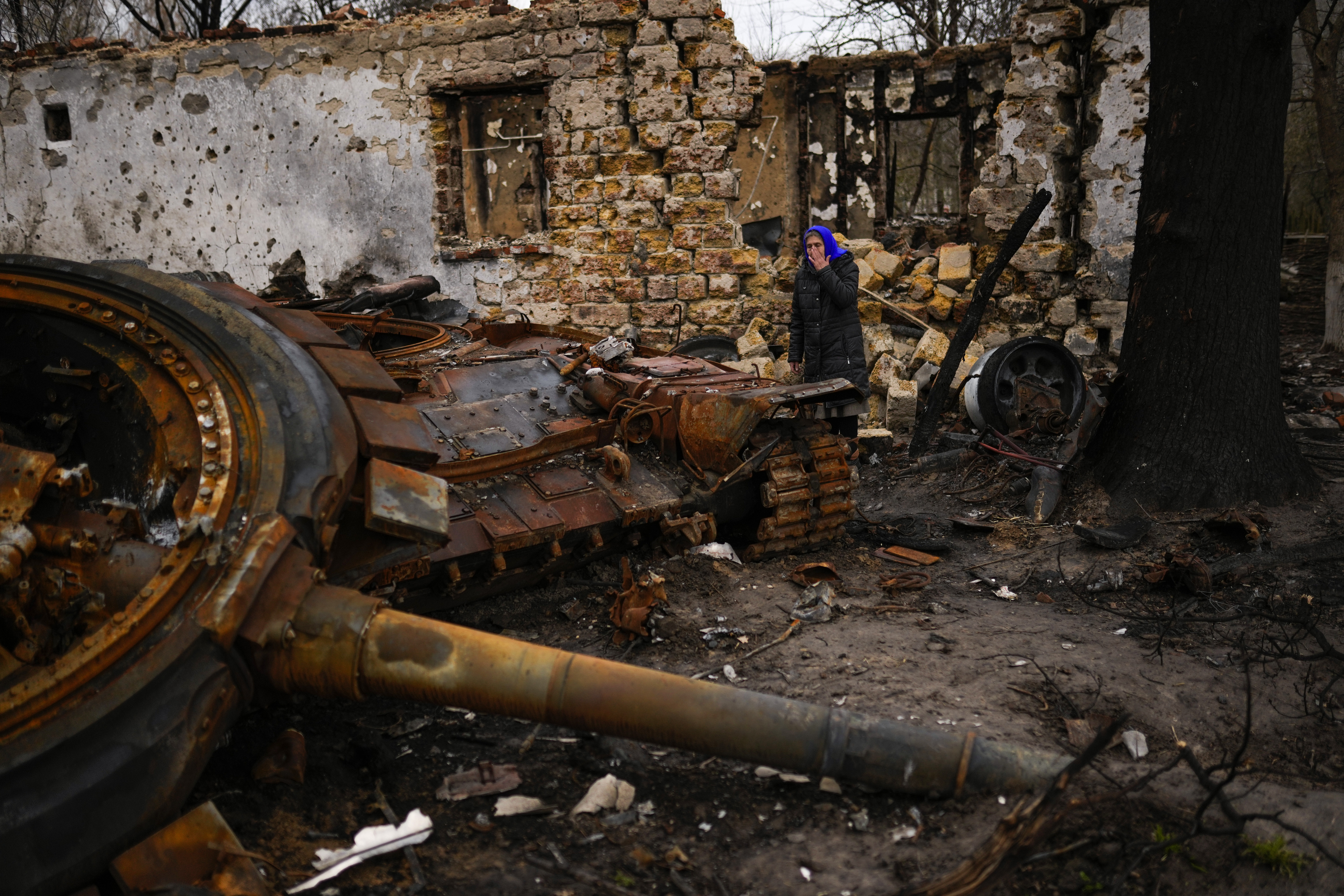 Valentyna Sherba, 68, stands next to a Russian tank in the backyard of her father's home, both destroyed, in the aftermath of a battle between Russian and Ukrainian troops on the outskirts of Chernihiv, northern Ukraine