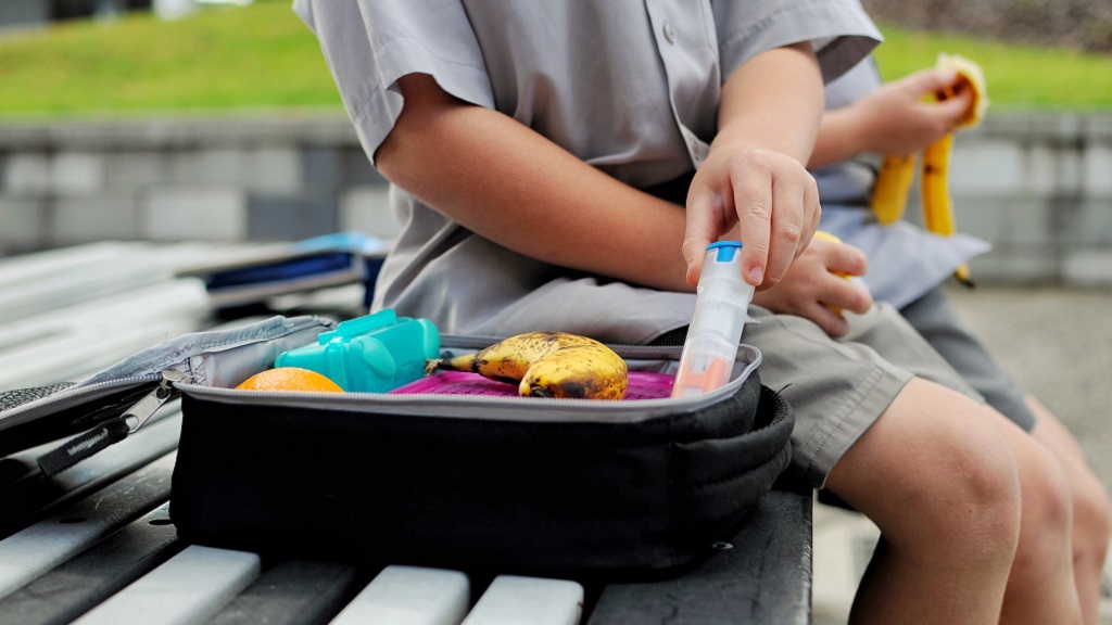 Child with EpiPen in lunch box