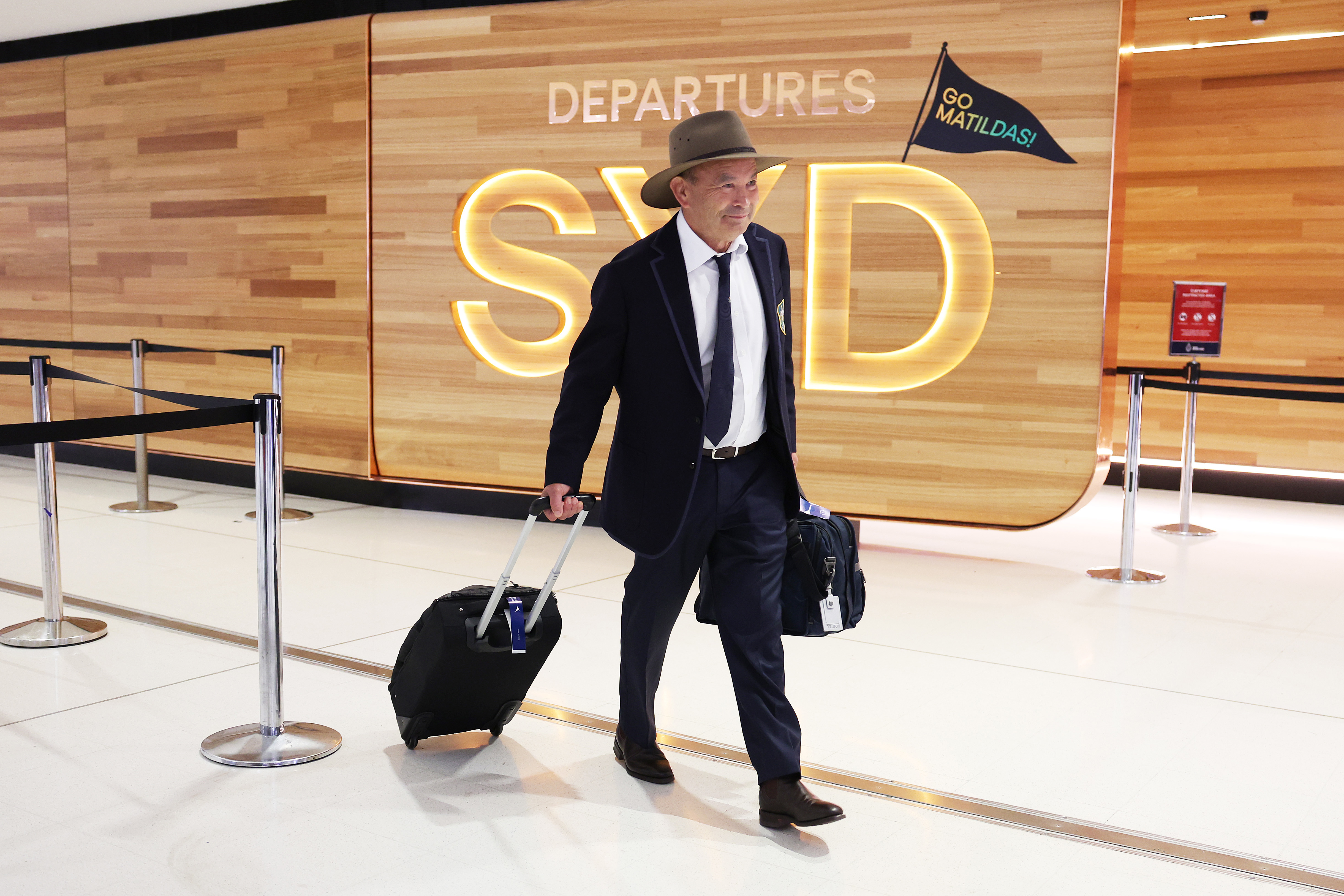 Wallabies head coach Eddie Jones heads to departures at Sydney International Airport.