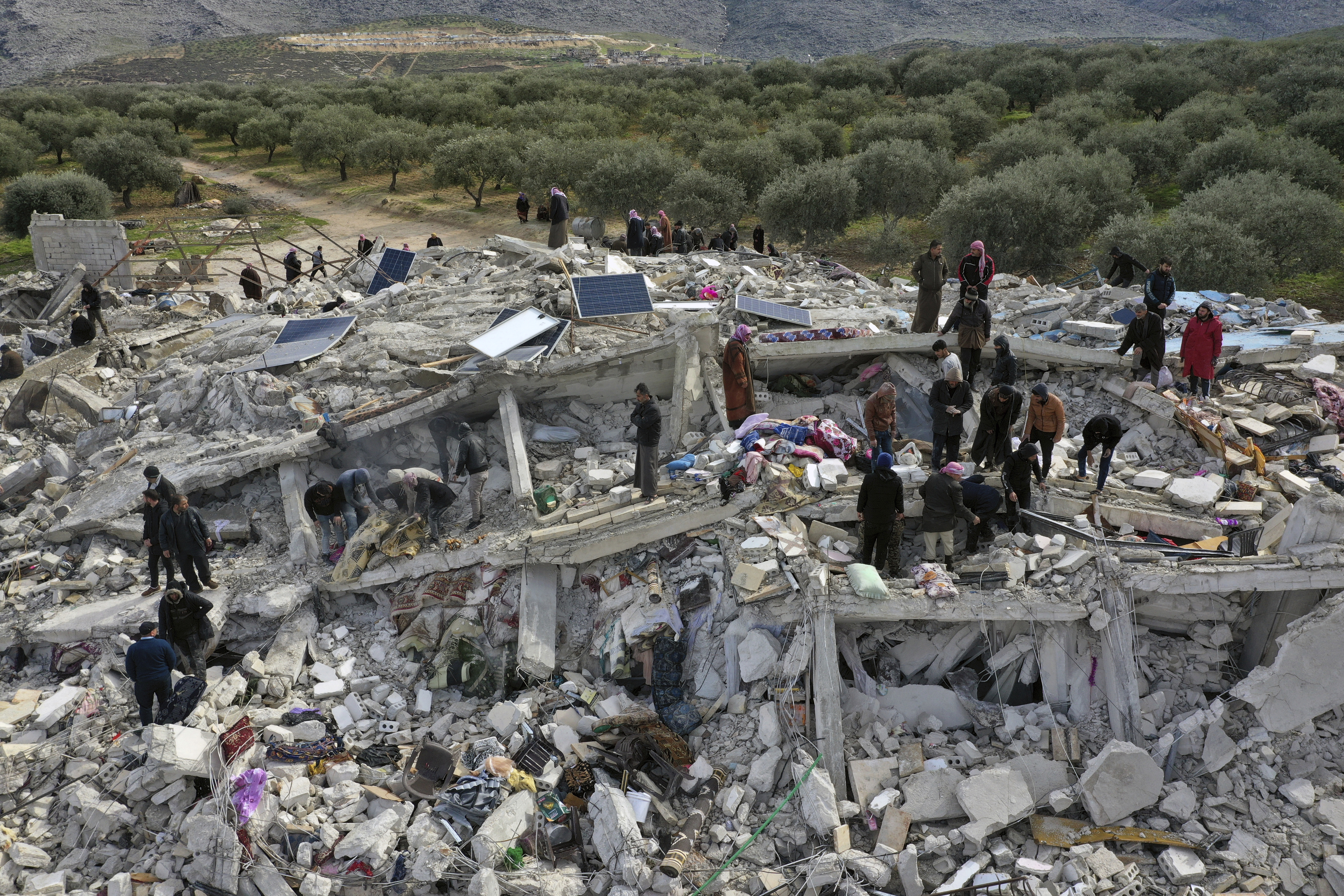 Civil defence workers and residents search through the rubble of collapsed buildings in the town of Harem near the Turkish border, Idlib province, Syria, Monday, Feb. 6, 2023.  