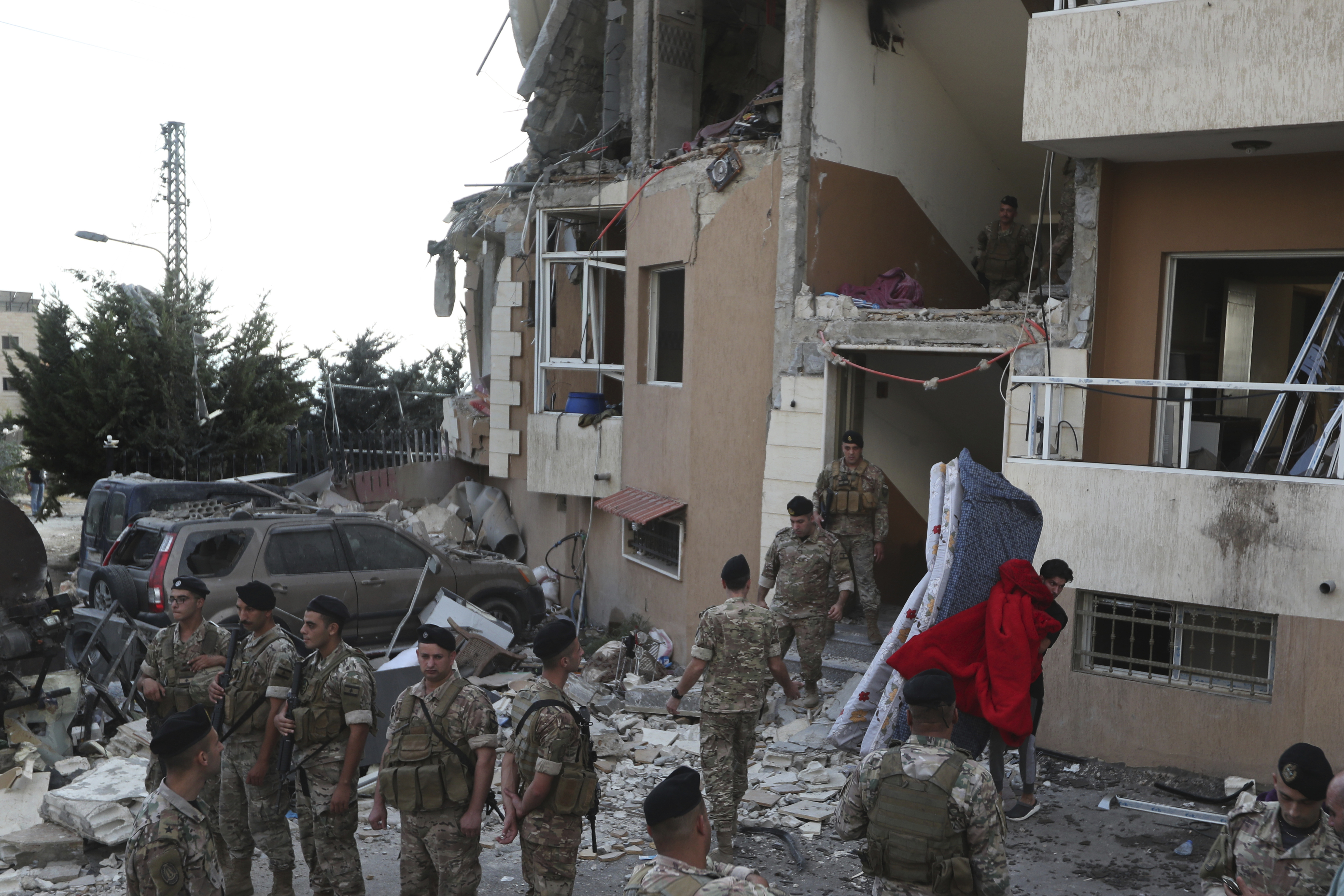 A man carries mattresses from a destroyed building hit by an Israeli airstrike, in Barja village, south of Beirut, Lebanon, Saturday, Oct. 12, 2024. (AP Photo/Mohammed Zaatari)