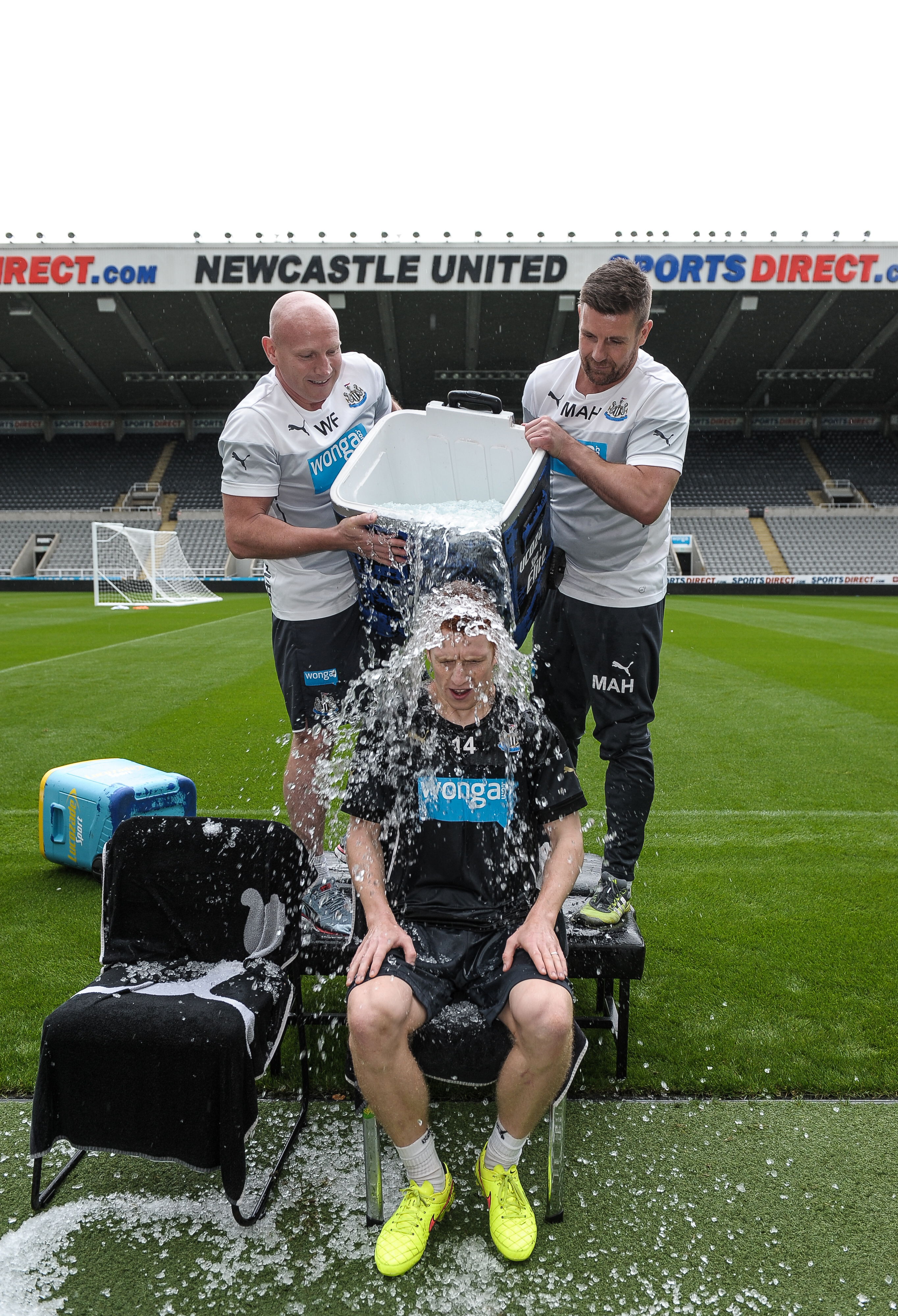 NEWCASTLE UPON TYNE, ENGLAND - AUGUST 29: Jack Colback participates in the ASL Ice Bucket Challenge with help from Masseurs Mick Holland (L) and Wayne Farrage (R) during a Newcastle United Training Session at St.James Park on August 29, 2014, in Newcastle upon Tyne, England. (Photo by Serena Taylor/Newcastle United via Getty Images)