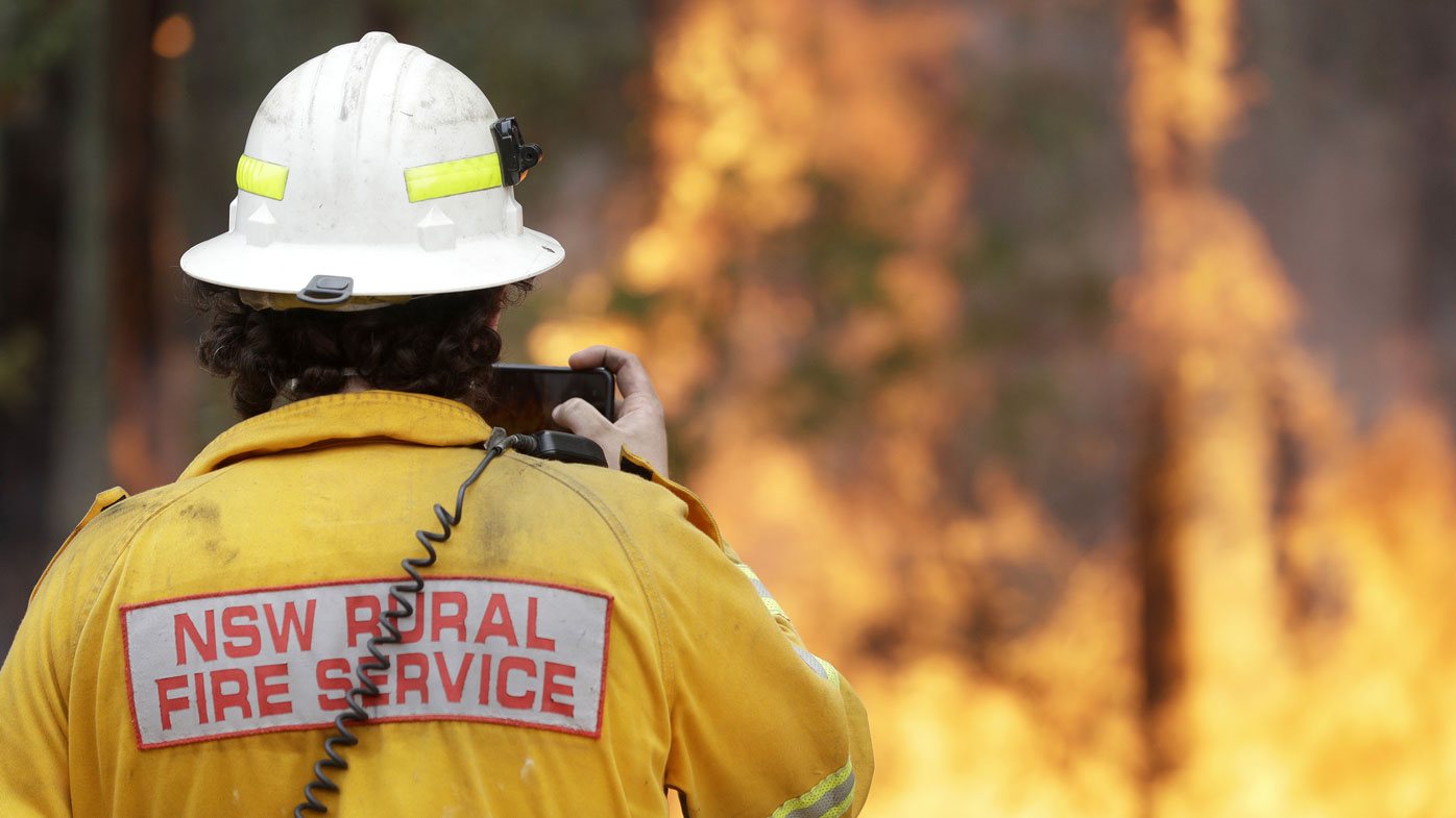 An RFS firefighter in front of a massive blaze.