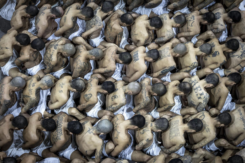 FILE - In this photo provided by El Salvador's presidential press office, inmates identified by authorities as gang members are moved at the prison, Terrorism Confinement Center, in Tecoluca, El Salvador, March 15, 2023. New rules passed by El Salvador's congress on Wednesday, July 26, 2023, will allow courts to try accused gang members in group trials, in an effort to expedite tens of thousands of criminal cases for those detained under the country's crackdown on street gangs. 