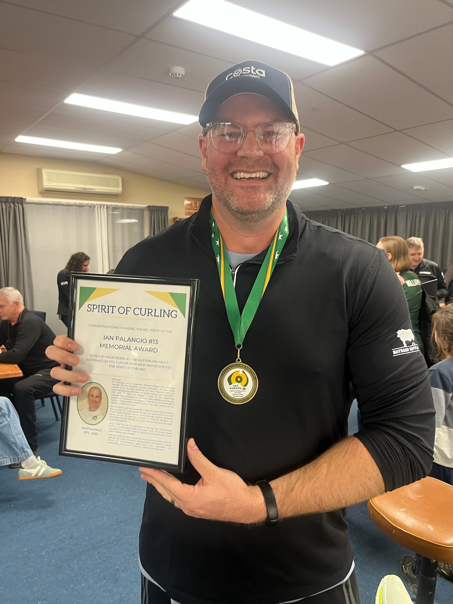 Andrew Swain poses with a 'Spirit of Curling' award.