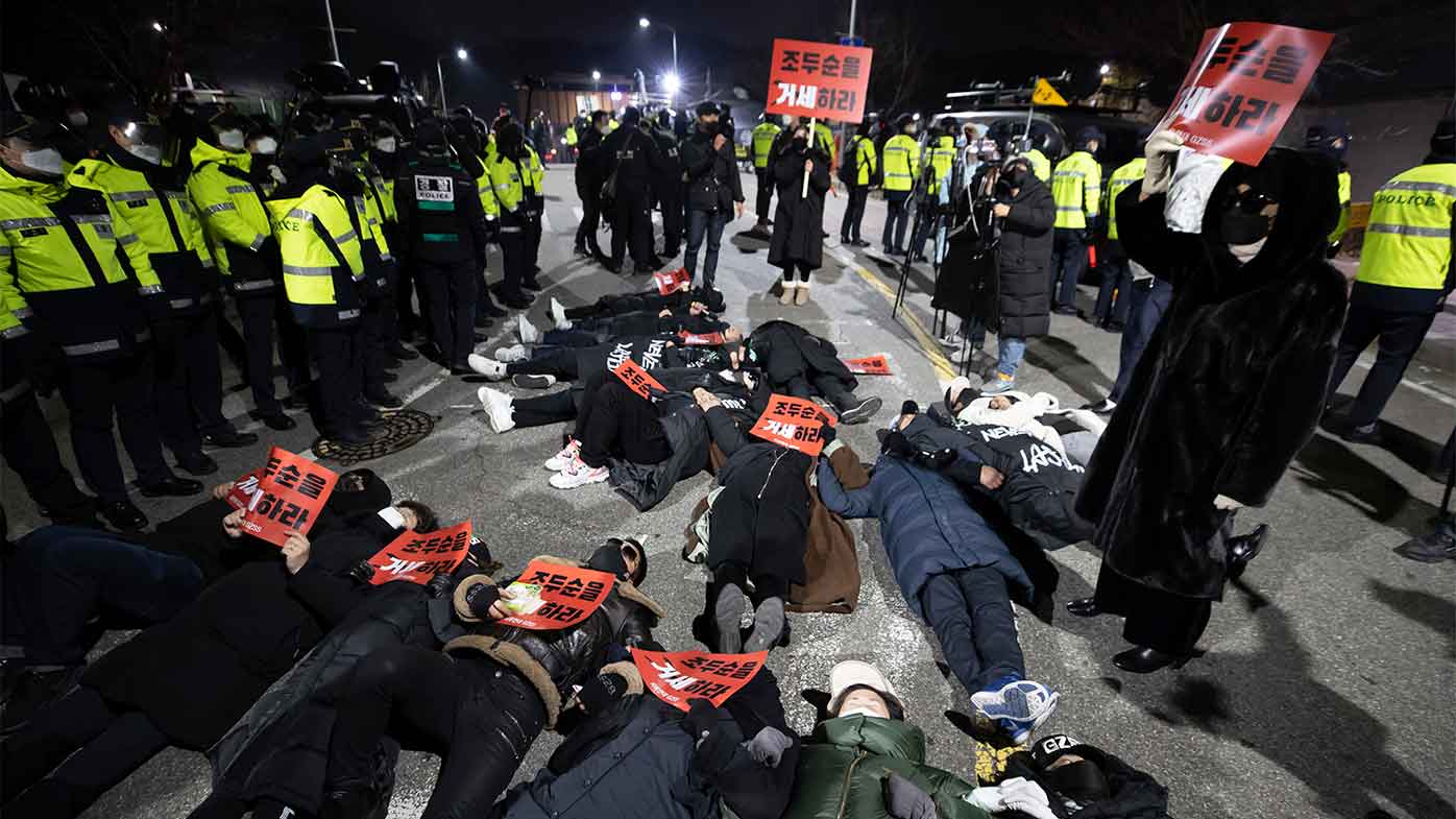 Protesters lie down on the road to oppose the release of Cho Doo-soon in front of a prison in Seoul.