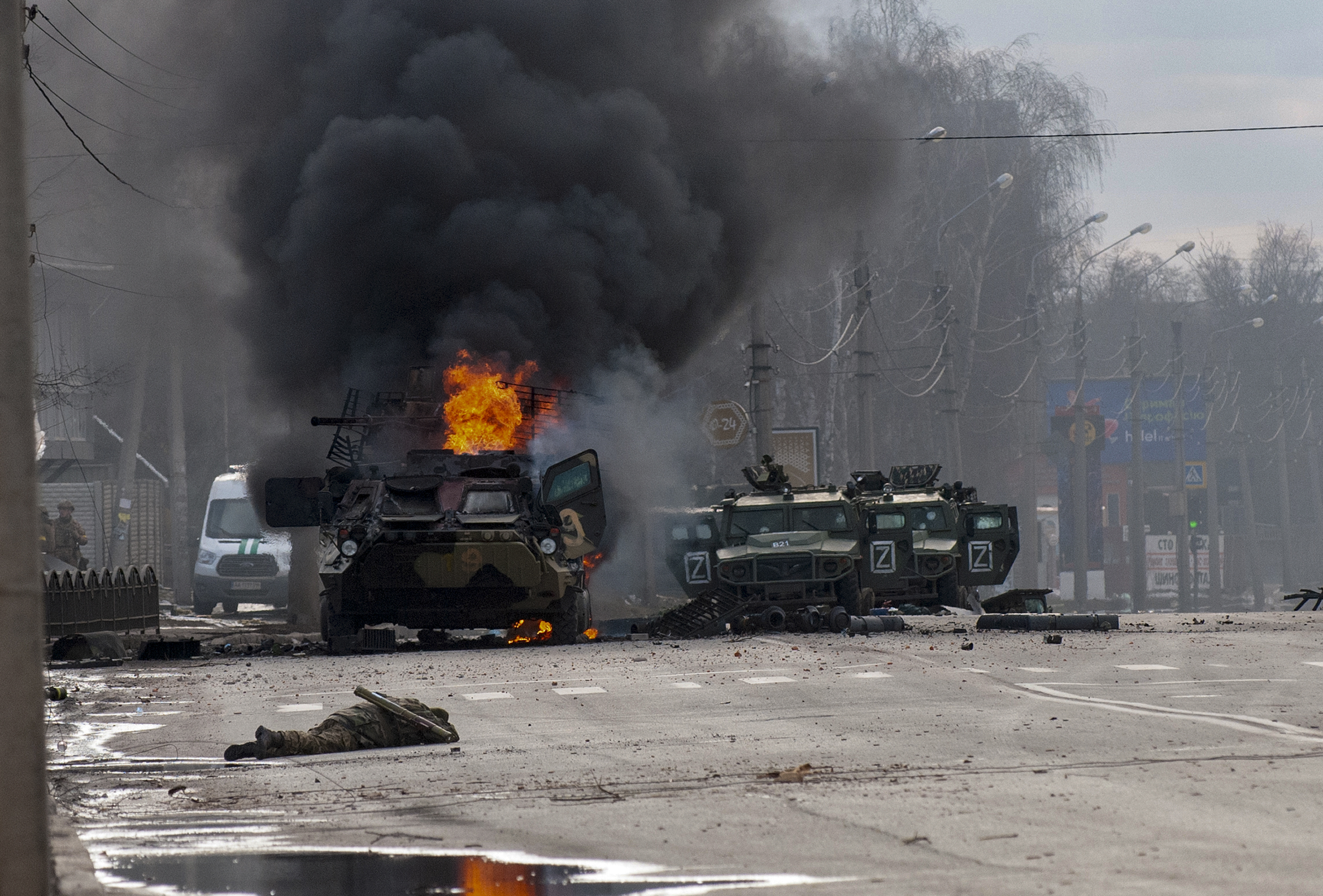 A Russian armoured personnel carrier burns amid damaged and abandoned light utility vehicles after fighting in Kharkiv, Ukraine, Sunday, Feb. 27, 2022. 