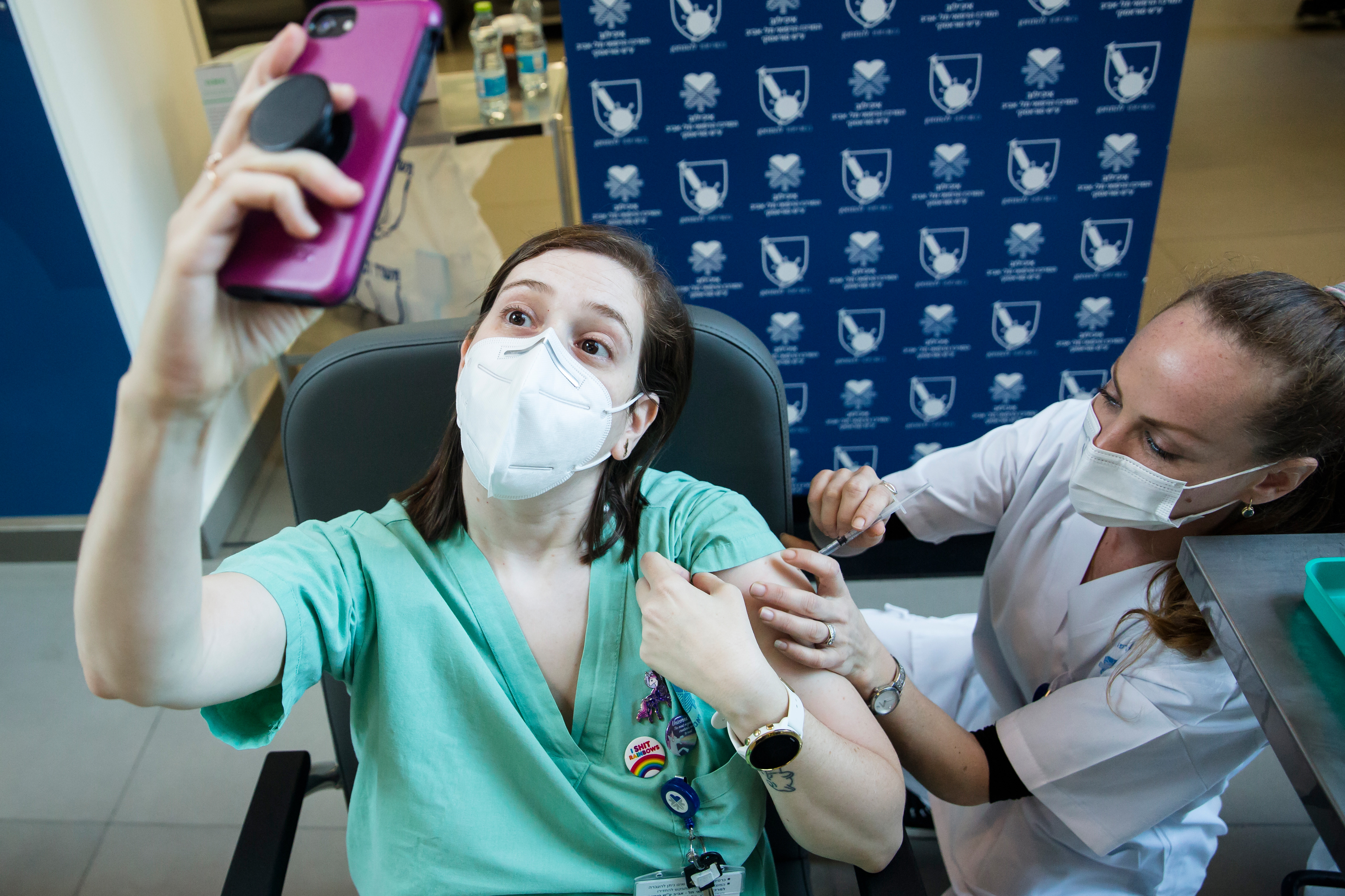 A medical staff member takes a photo as she is vaccinated by a medical worker against coronavirus at Tel Aviv Sourasky Medical Centre in Israel.