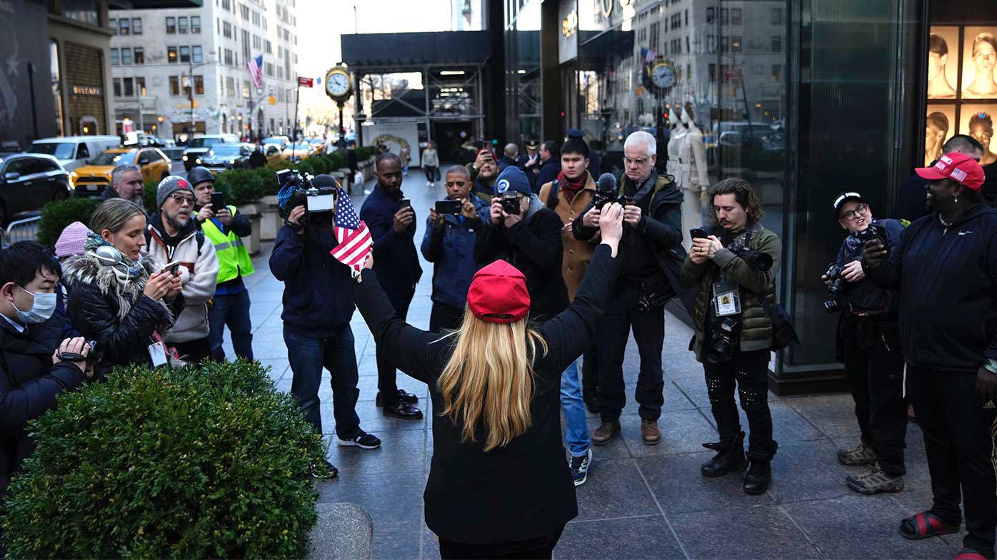 Un manifestante solitario afuera de la Torre Trump está rodeado por los medios.