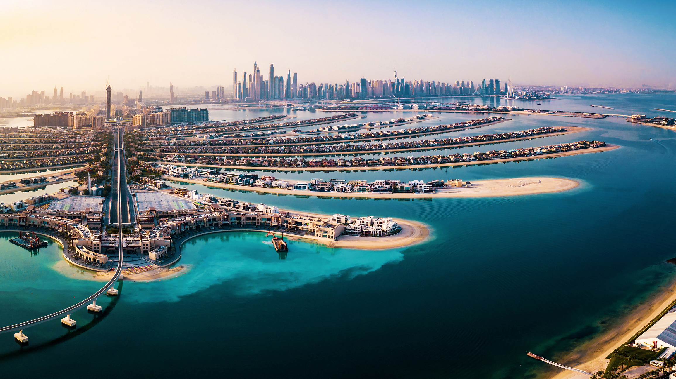 The Palm island panorama with Dubai marina rising in the background aerial view