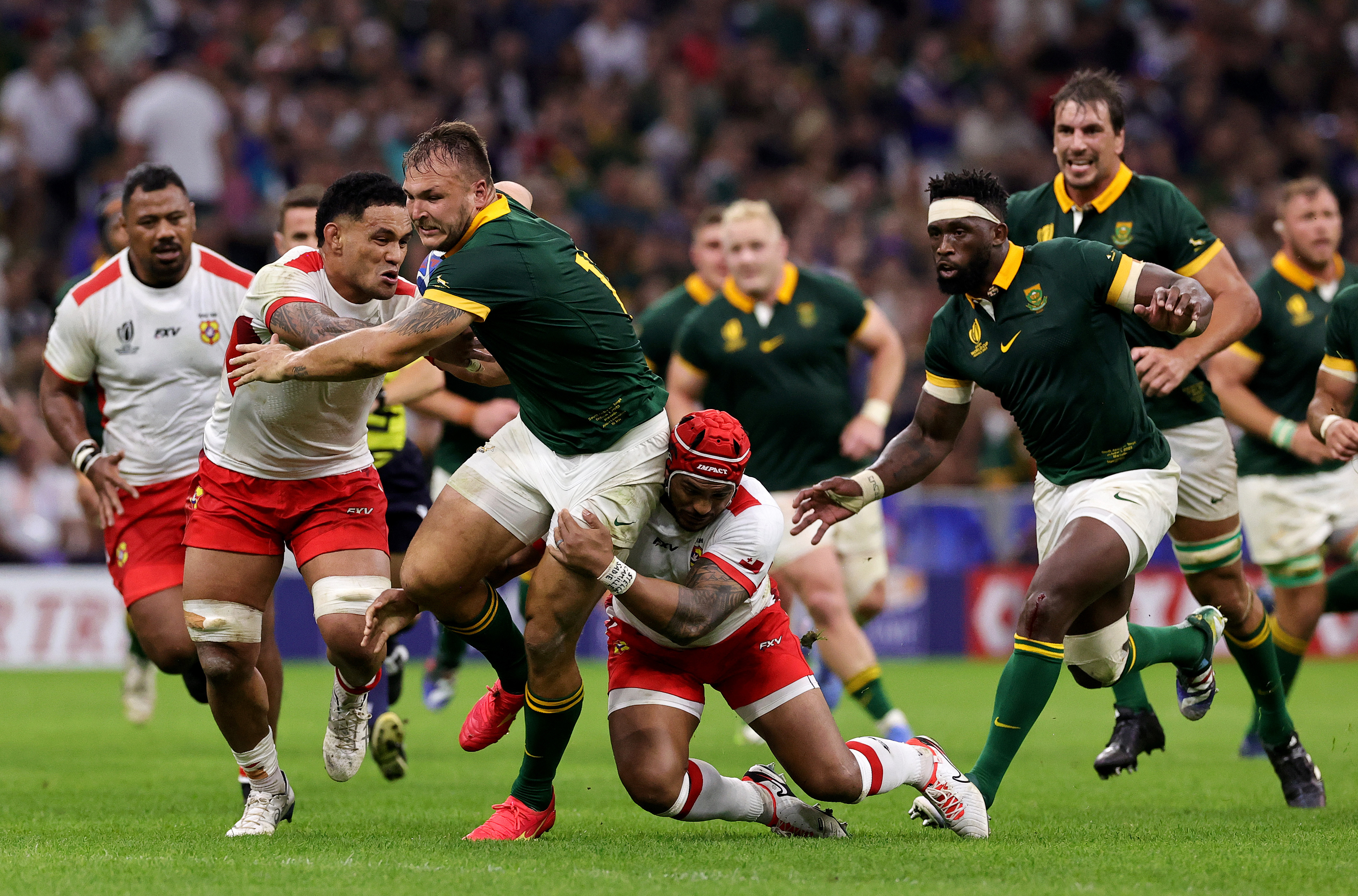 Andre Esterhuizen of South Africa is tackled by Sione Talitui and Pita Ahki of Tonga.