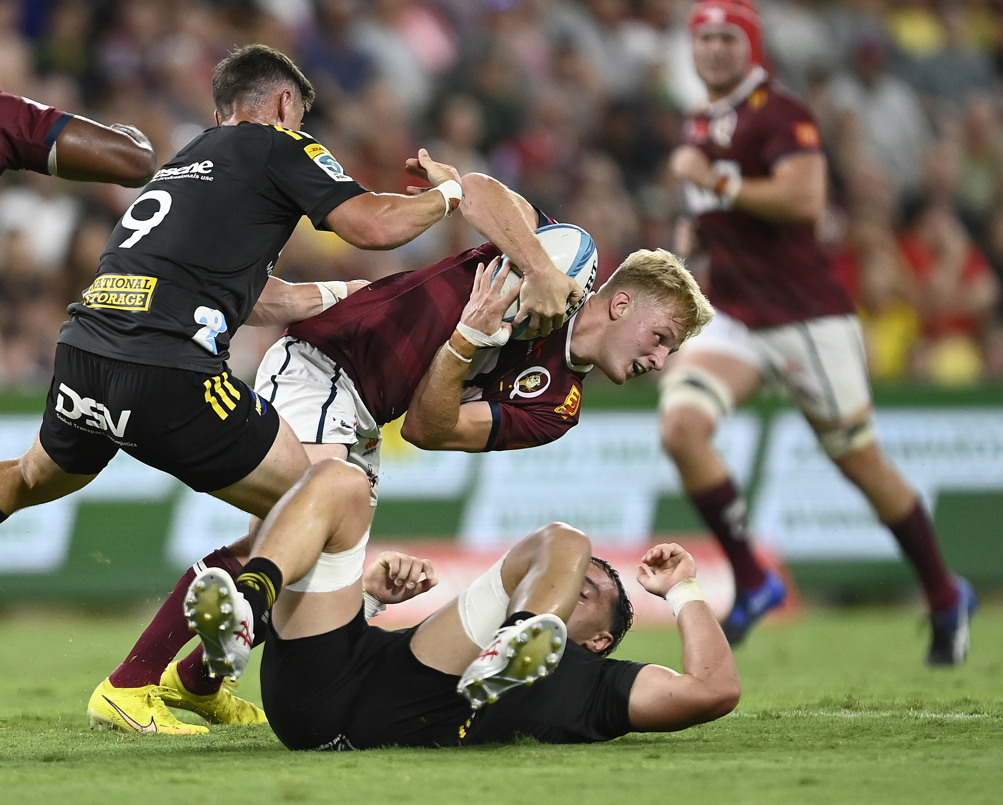 Tom Lynagh of the Reds is tackled.