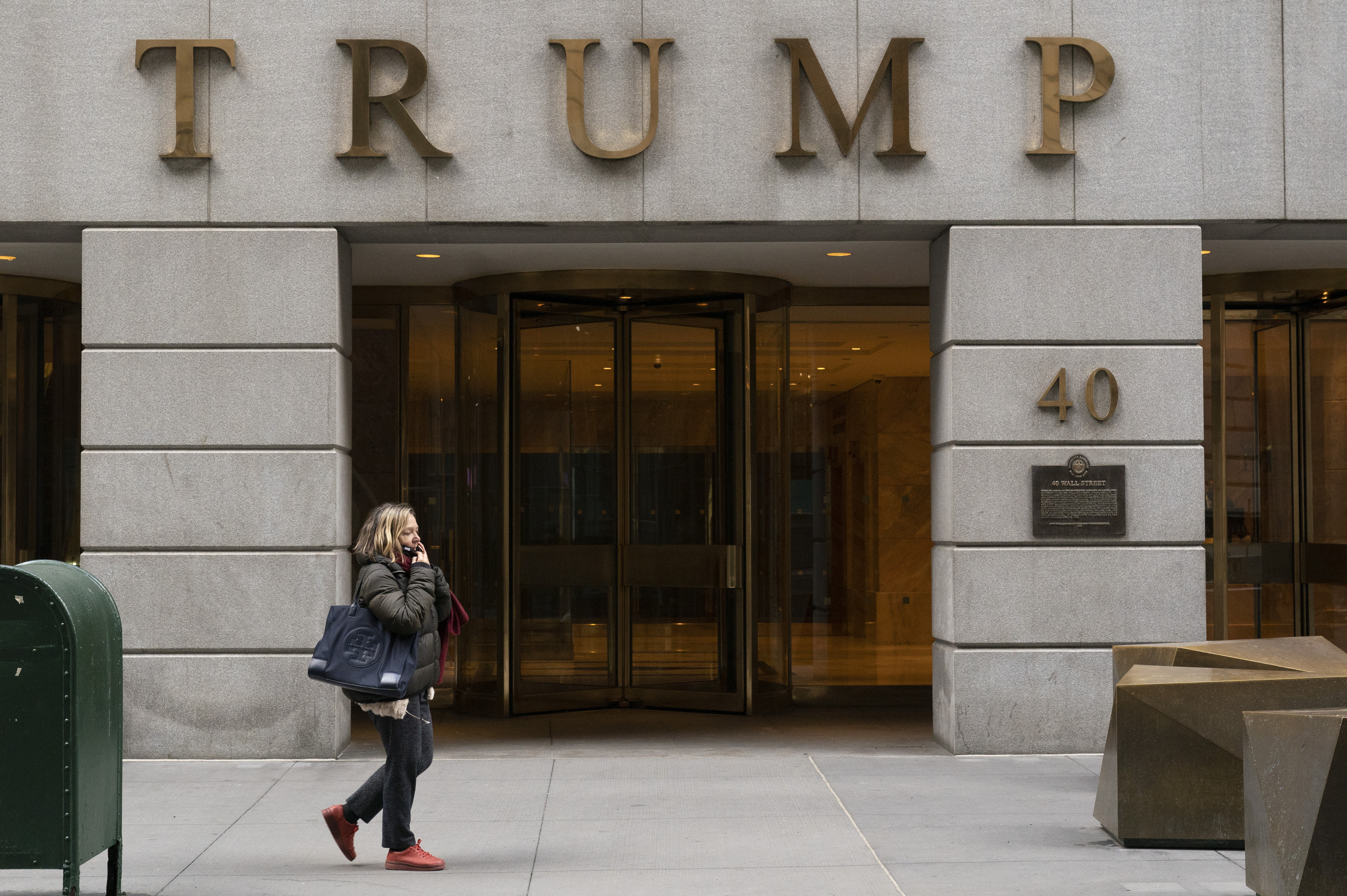 FILE - A woman walks past the Trump Building in New York's financial district, Wednesday, Jan. 13, 2021. Mazars USA LLP, the accounting firm that prepared former President Donald Trumps annual financial statements, says the documents should no longer be relied upon after investigators said they found evidence he and his company regularly misstated the value of assets. (AP Photo/Mark Lennihan, File)
