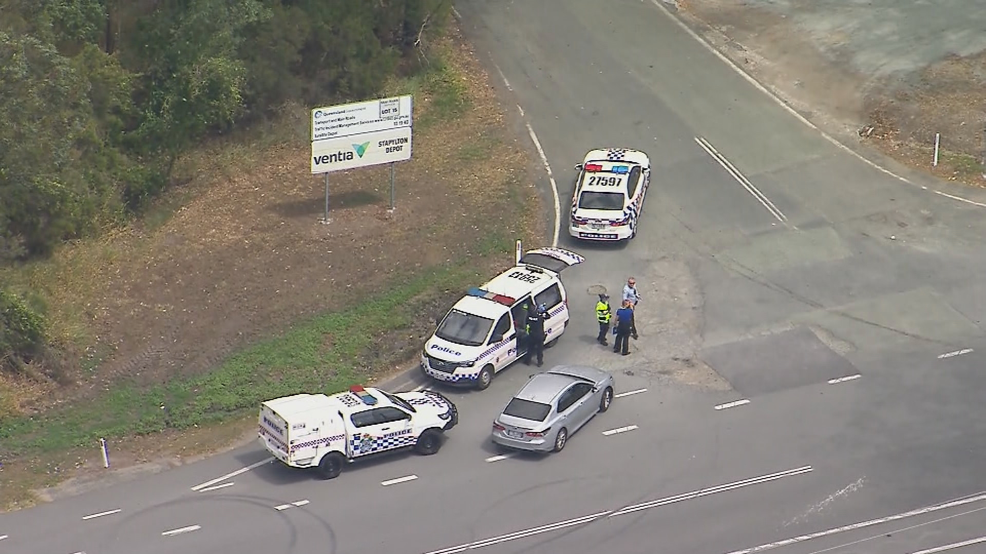 An aerial shot of multiple police cars on a road in QLD.