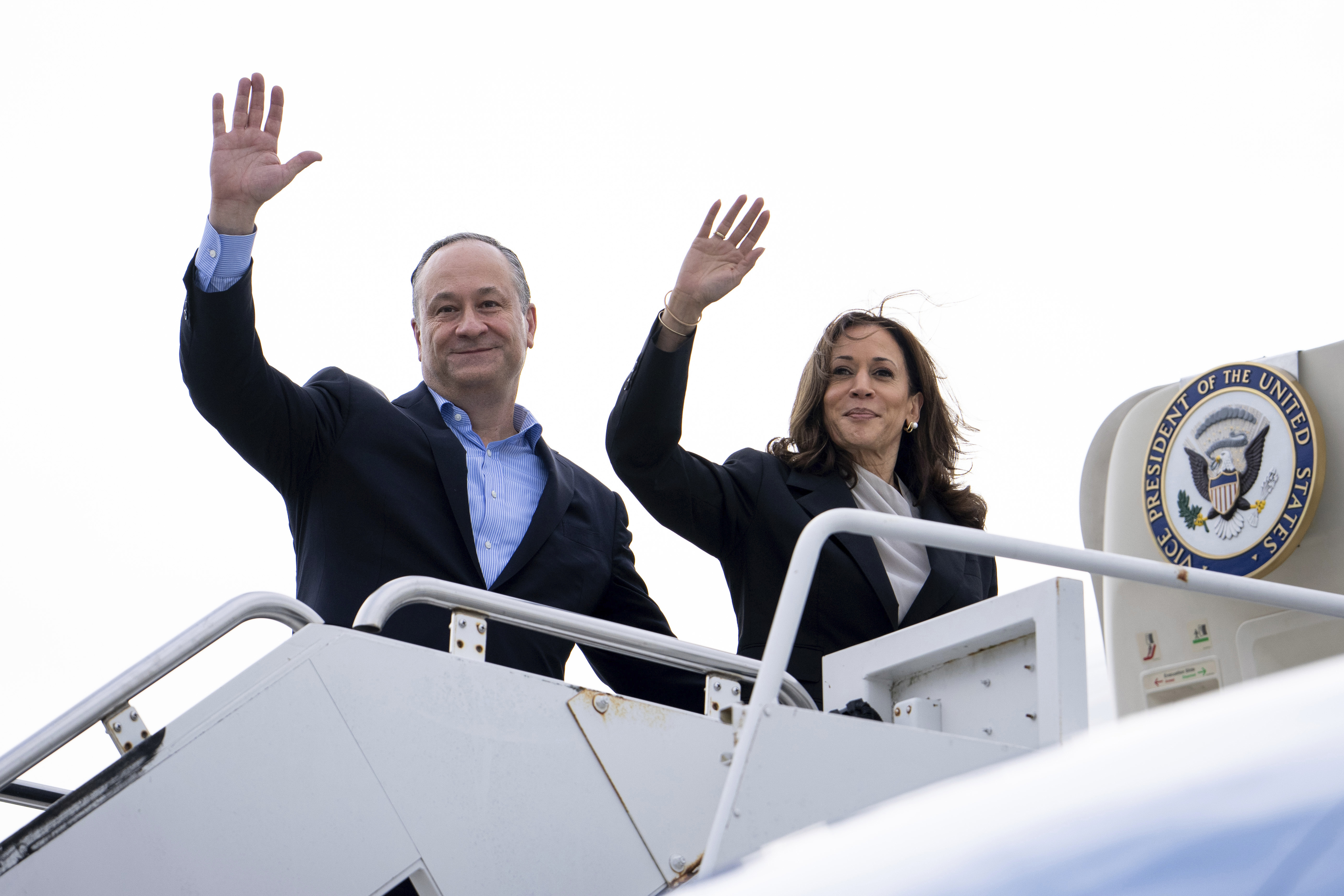 La vicepresidenta Kamala Harris, a la derecha, y el segundo caballero Douglas Emhoff saludan desde el Air Force Two en la base de la Guardia Nacional Aérea de Delaware en New Castle, Delaware, el lunes 22 de julio de 2024, después de visitar la sede de su campaña. (Erin Schaff/The New York Times vía AP, Pool)