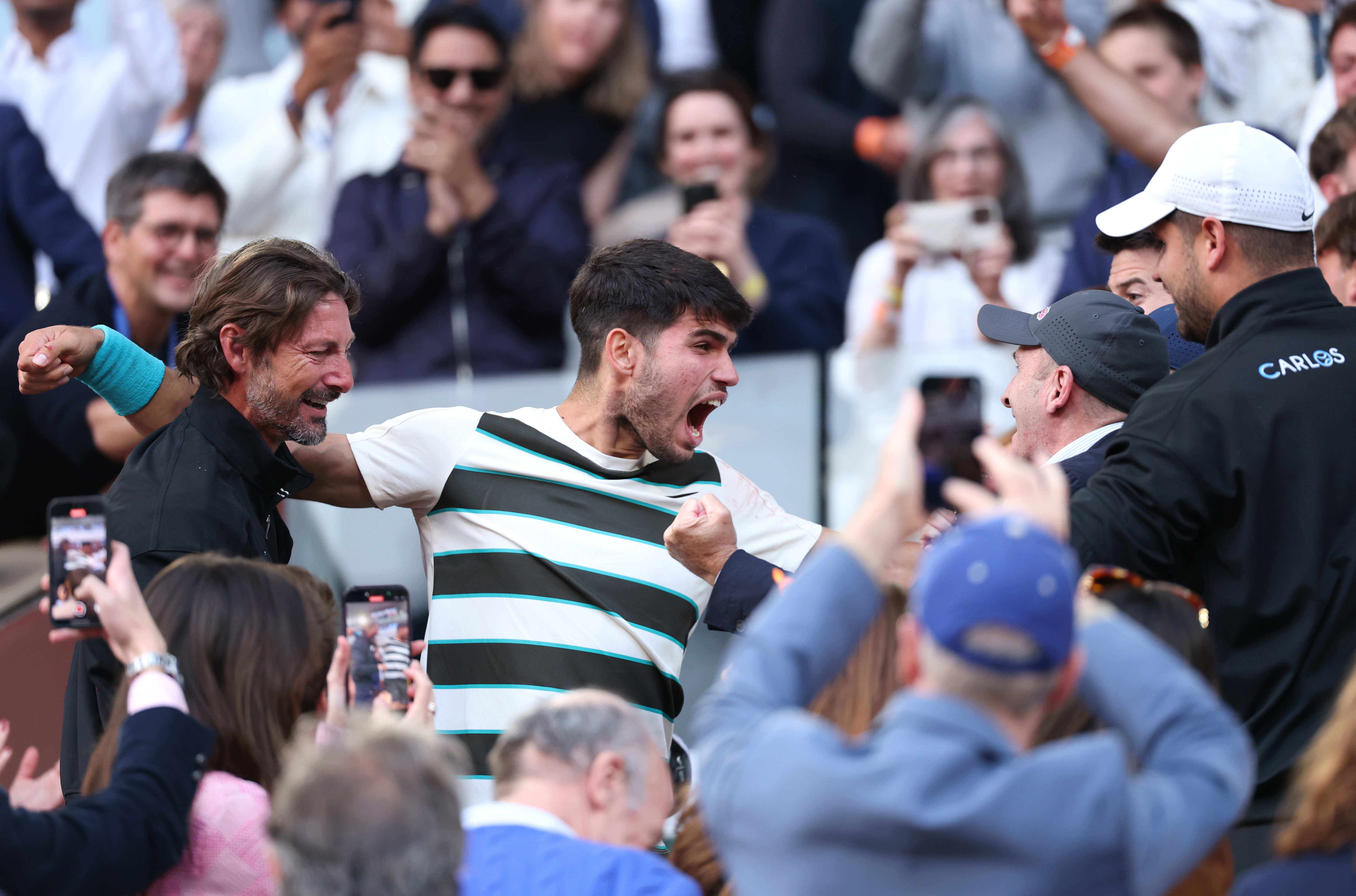 Carlos Alcaraz of Spain celebrates with his team and family following his victory over Jannik Sinner.