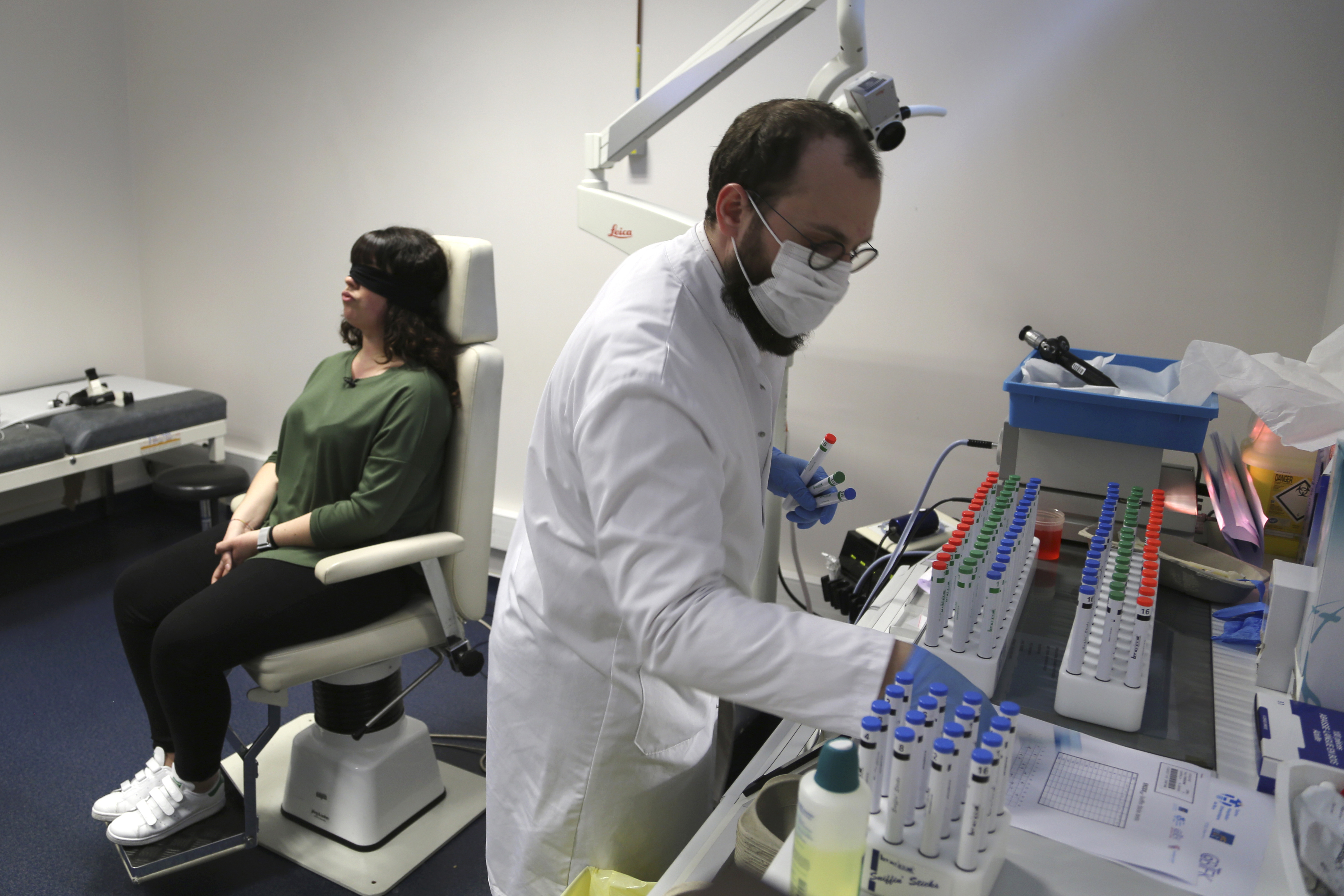 Dr. Clair Vandersteen, right, assembles tubes of odors to waft under the nose of a blindfolded patient, Gabriella Forgione, during tests in a hospital in Nice, France, on Monday, Feb. 8, 2021