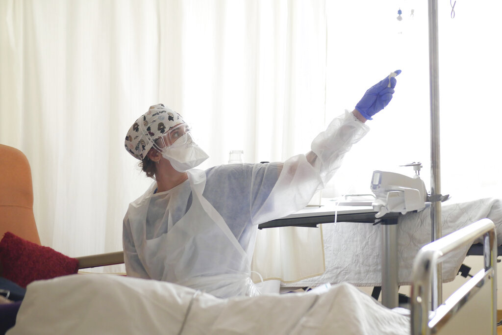 In this March 19, 2021, file photo, a nurse tends to a patient affected by COVID-19 virus in the ICU unit at the Ambroise Pare clinic in Neuilly-sur-Seine.