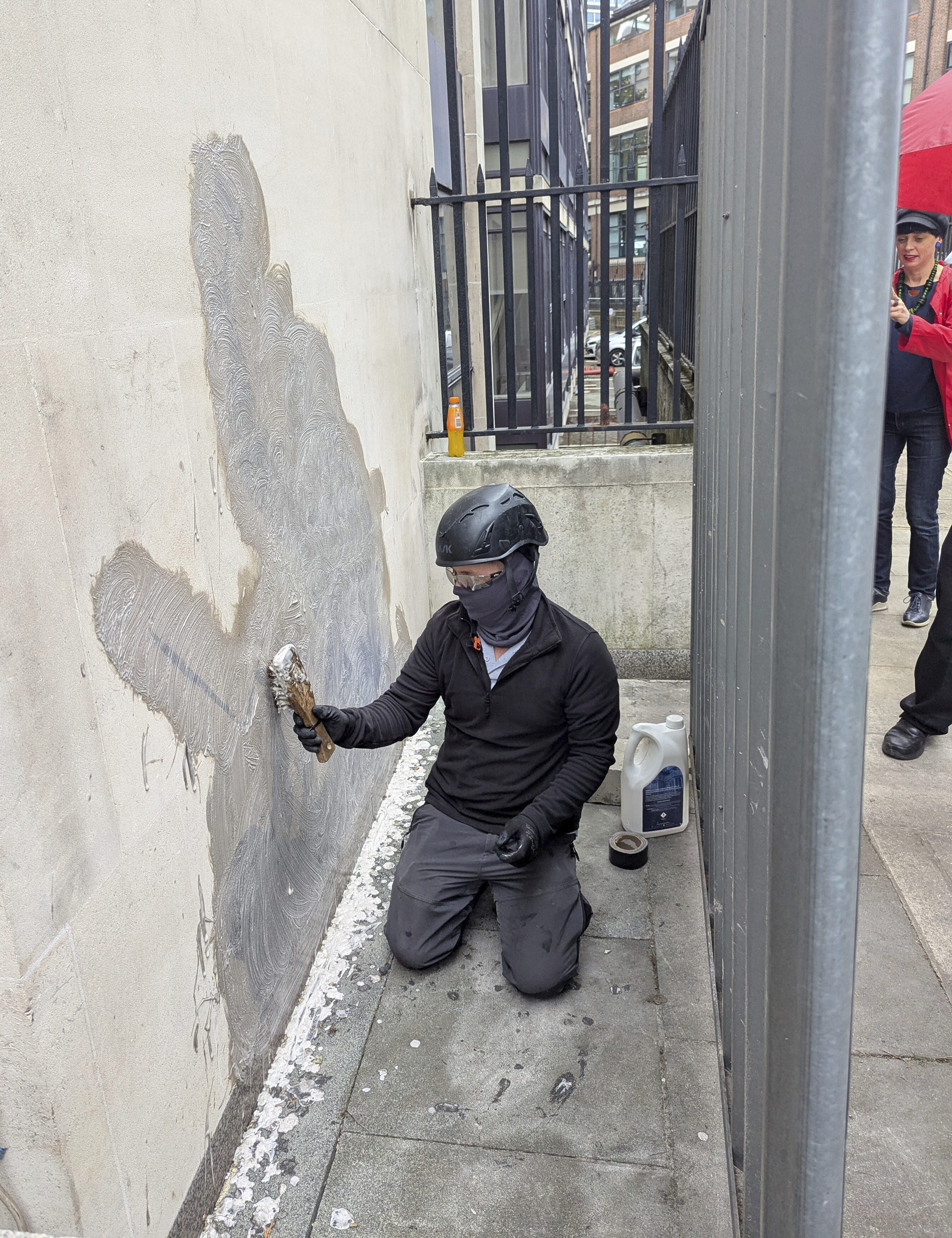 A worker removes the new artwork by Banksy, which shows a judge attacking a protester with a gavel, after it appeared at the Royal Courts of Justice in London on Monday, on Wednesday, Sept. 10, 2025. (Danny Halpin/PA via AP)