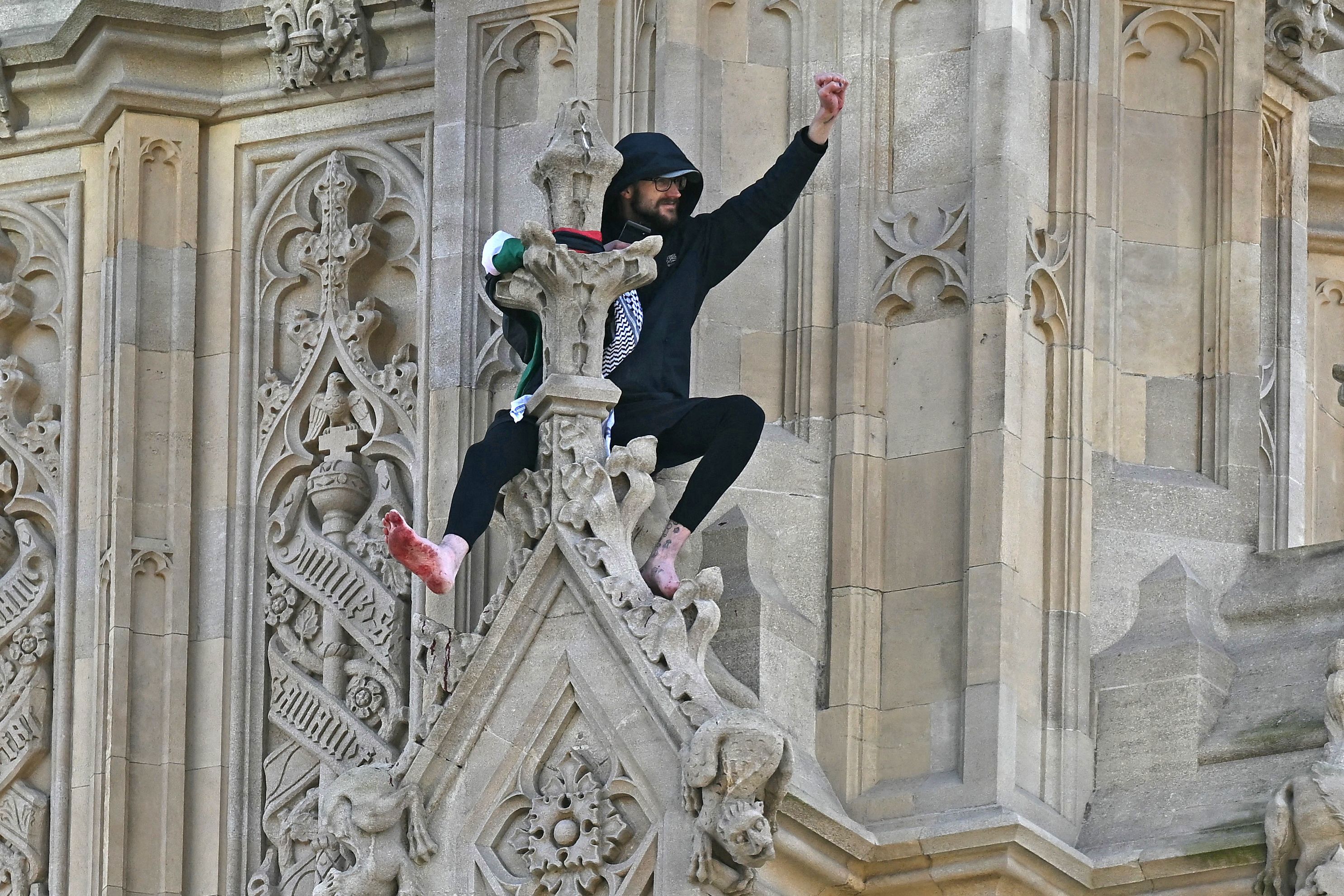 A protestor has climbed several meters up the Elizabeth Tower, commonly known as "Big Ben," and stood barefoot on a ledge holding a Palestinian flag.