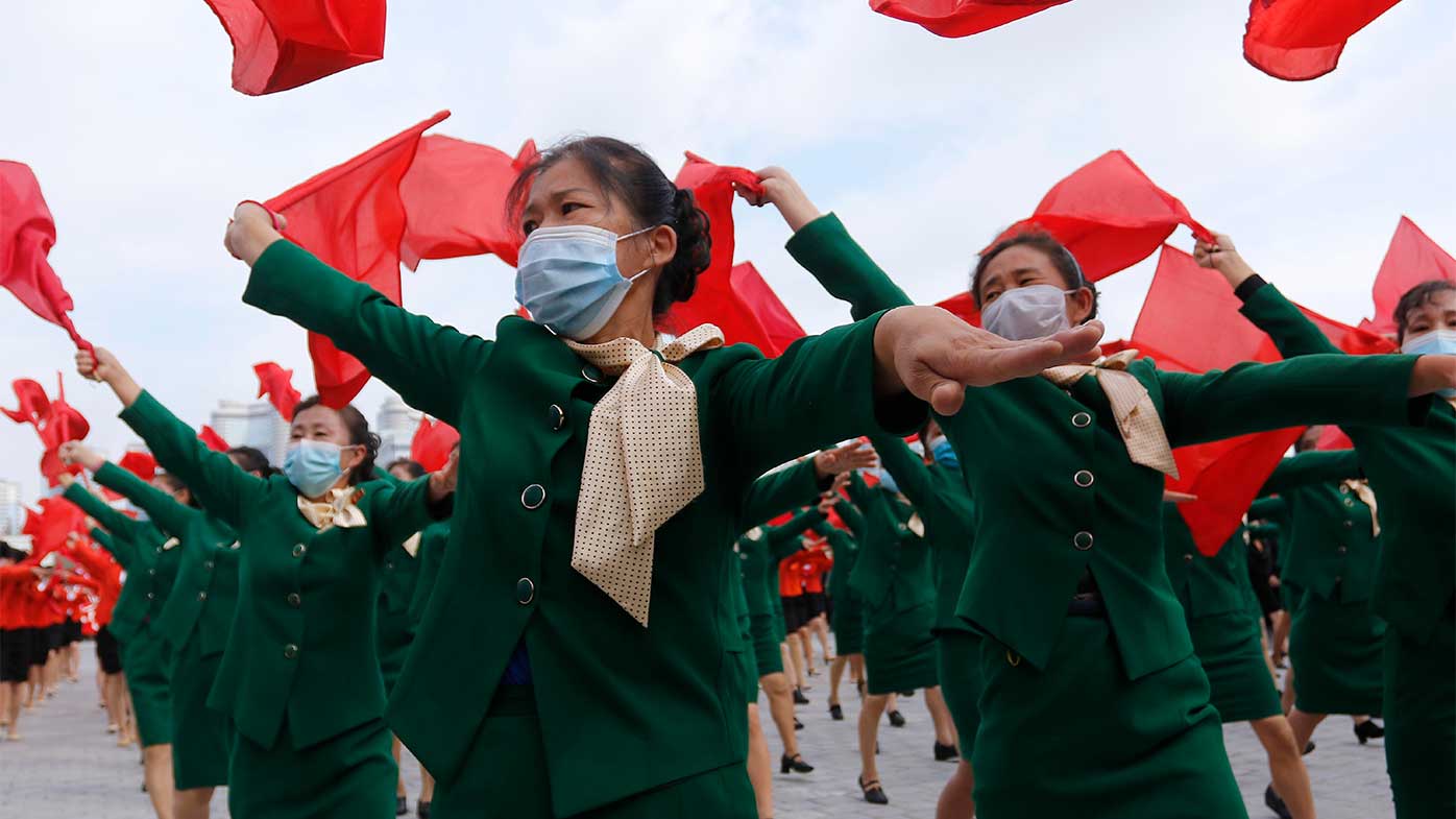 Women parade with flags during a rally to welcome the 8th Congress of the Workers' Party of Korea in the Party at Kim Il Sung Square in Pyongyang, North Korea.