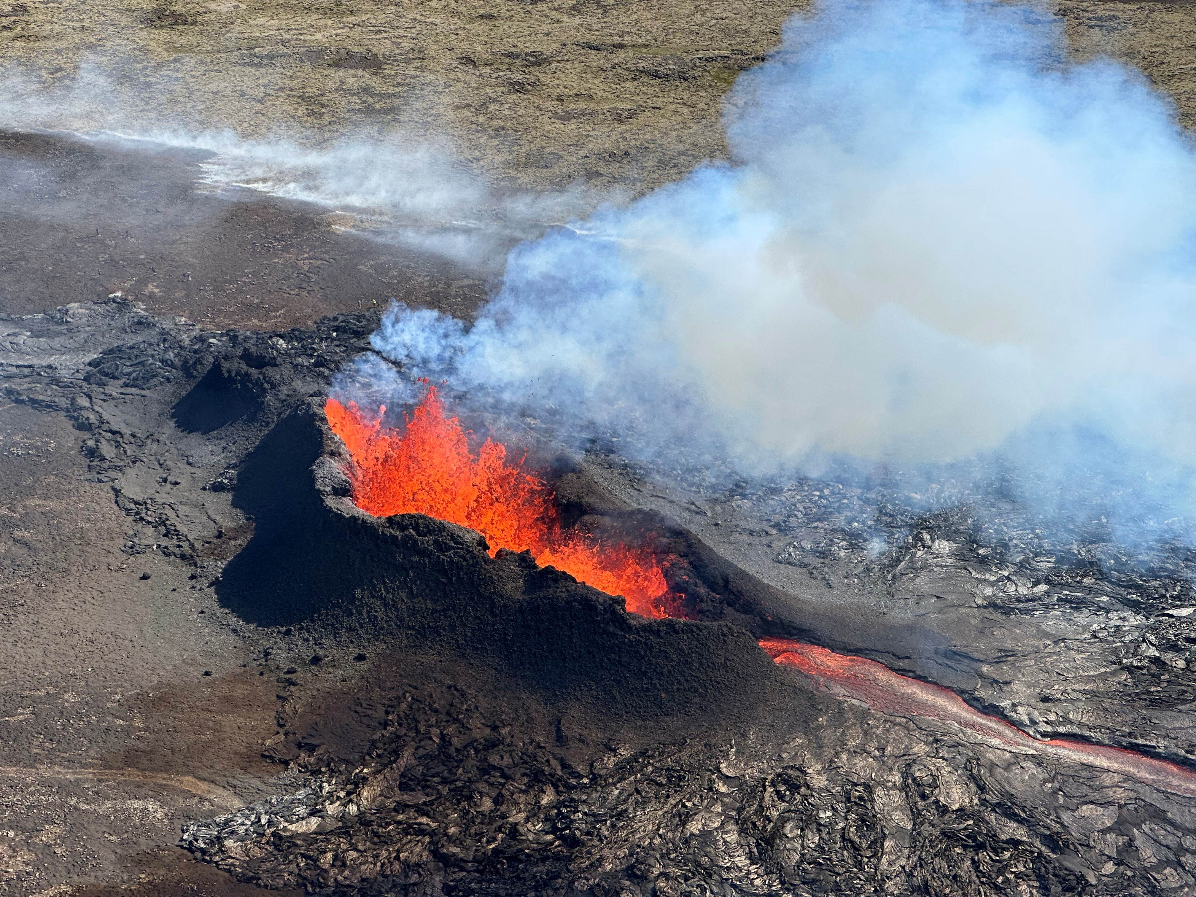 Lava spurts and flows after the eruption of a volcano in the Reykjanes Peninsula, Iceland, July 12, 2023, as seen in this handout picture taken from a Coast Guard helicopter. 