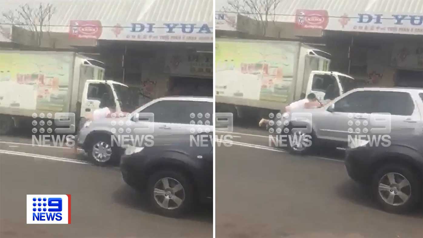 A man is seen clinging to the bonnet of the Honda in Homebush West.