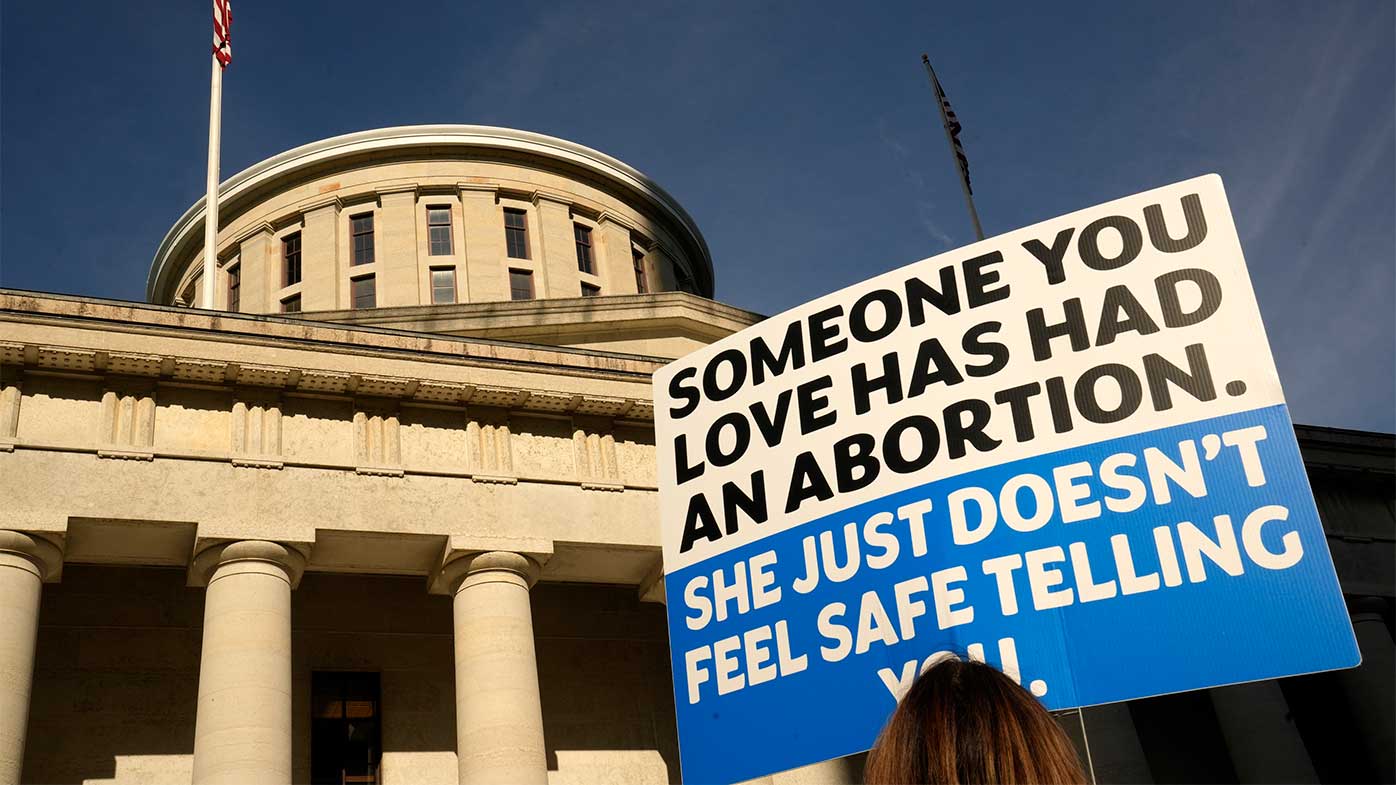 Un manifestante sostiene un cartel frente al Capitolio del Estado de Ohio en Columbus, donde presuntamente violaron y embarazaron a una niña de 10 años.