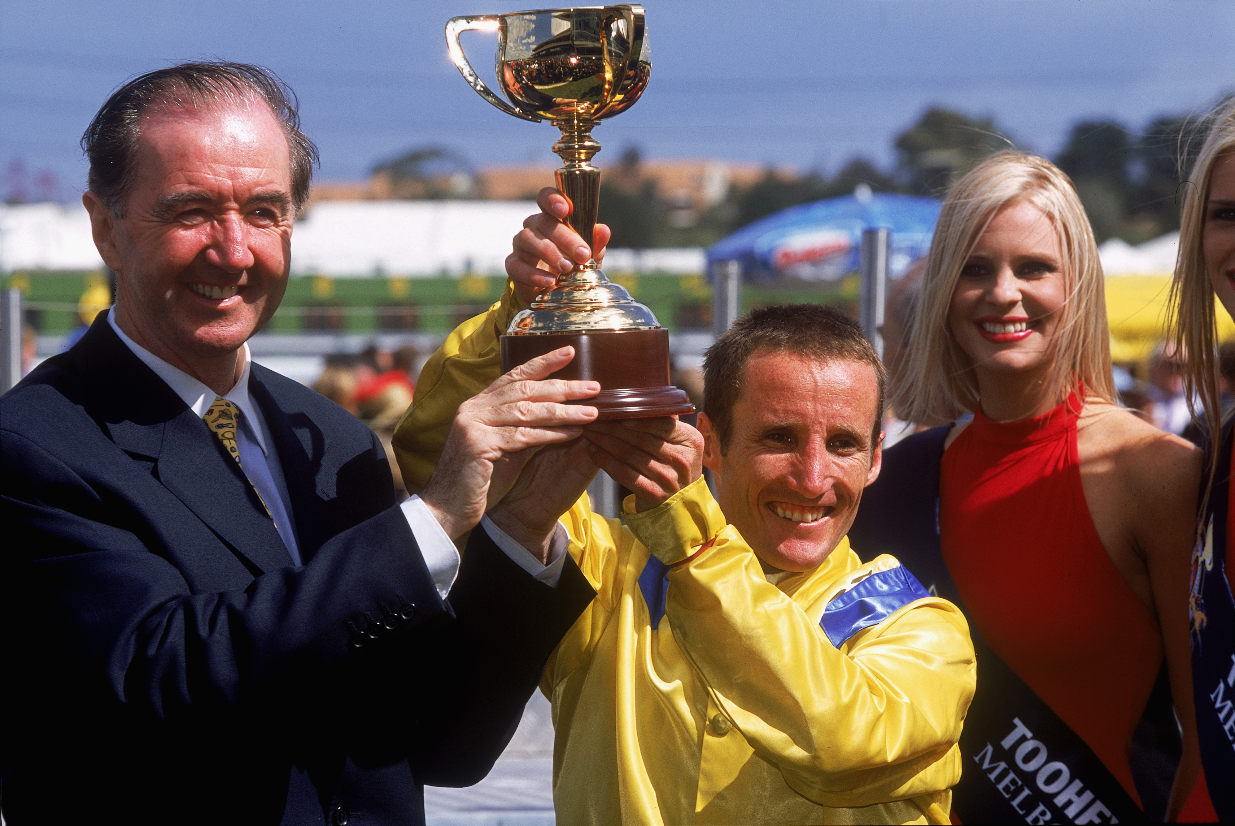 MELBOURNE - NOVEMBER 5: Damien Oliver, jockey of Media Puzzle, and Trainer Dermott Weld hold the Melbourne Cup trophy after winning the Tooheys New Melbourne Cup at Flemington Racecourse in Melbourne, Australia on November 5, 2002. (Photo by Nick Laham/Getty Images)