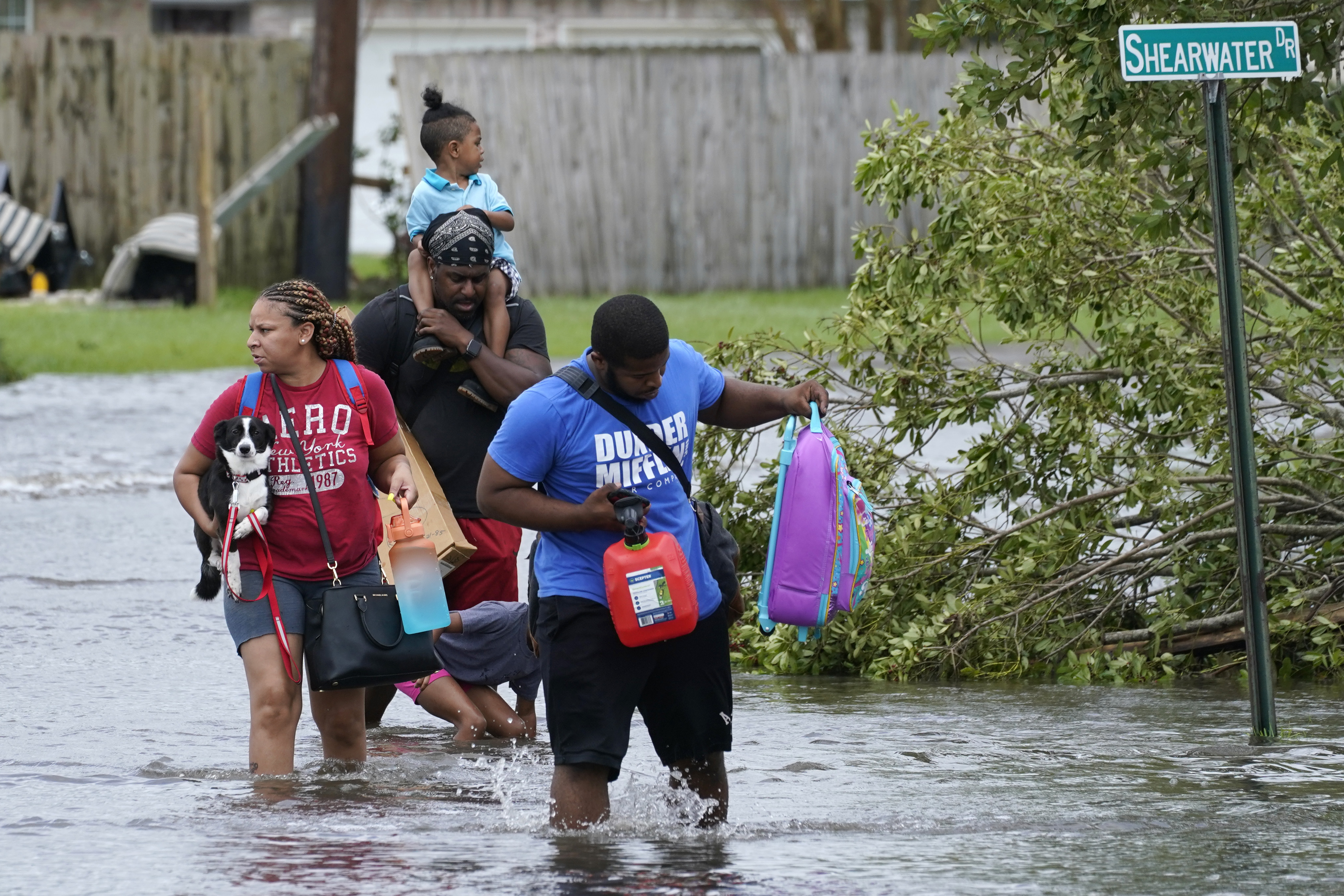 Michael Thomas, back, carries his daughter Mikala, out of his flooded neighborhood after Hurricane Ida moved through on Monday (local time).