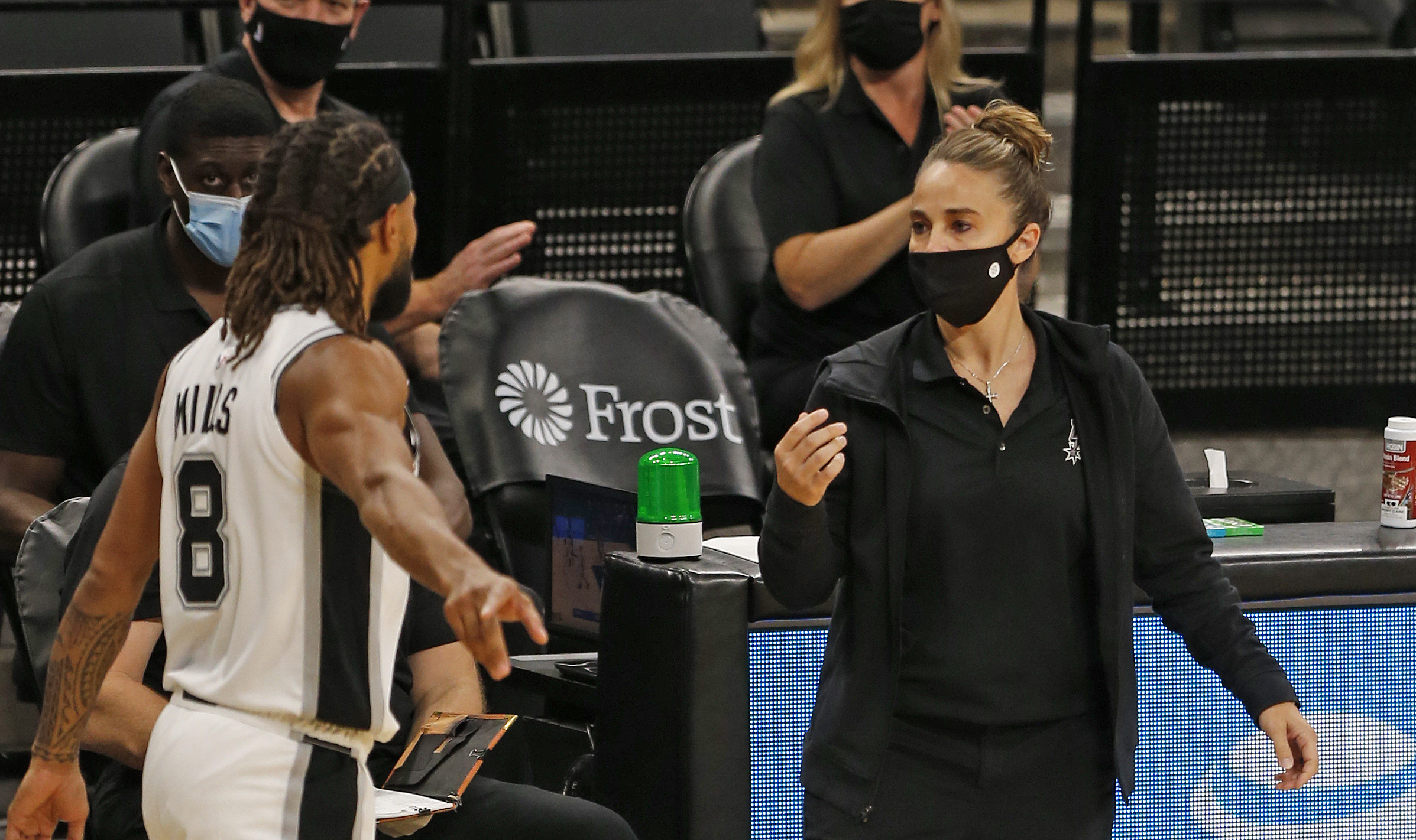 Becky Hammon of the San Antonio Spurs talks with Patty Mills.