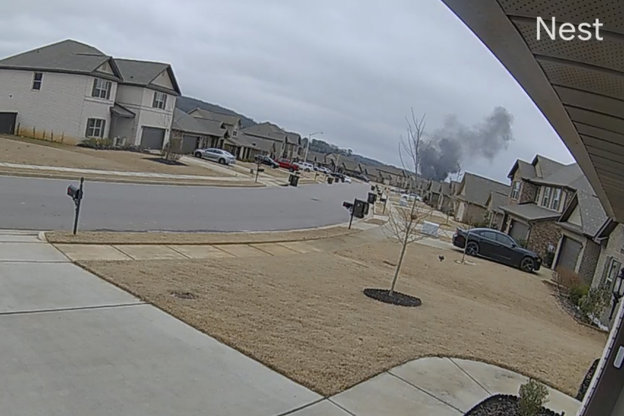 En esta imagen hecha a partir de un video tomado con una cámara Nest proporcionada por Mia McShan, una nube de humo negro se eleva desde donde se estrelló un helicóptero Black Hawk el miércoles 15 de febrero de 2023 en Alabama.