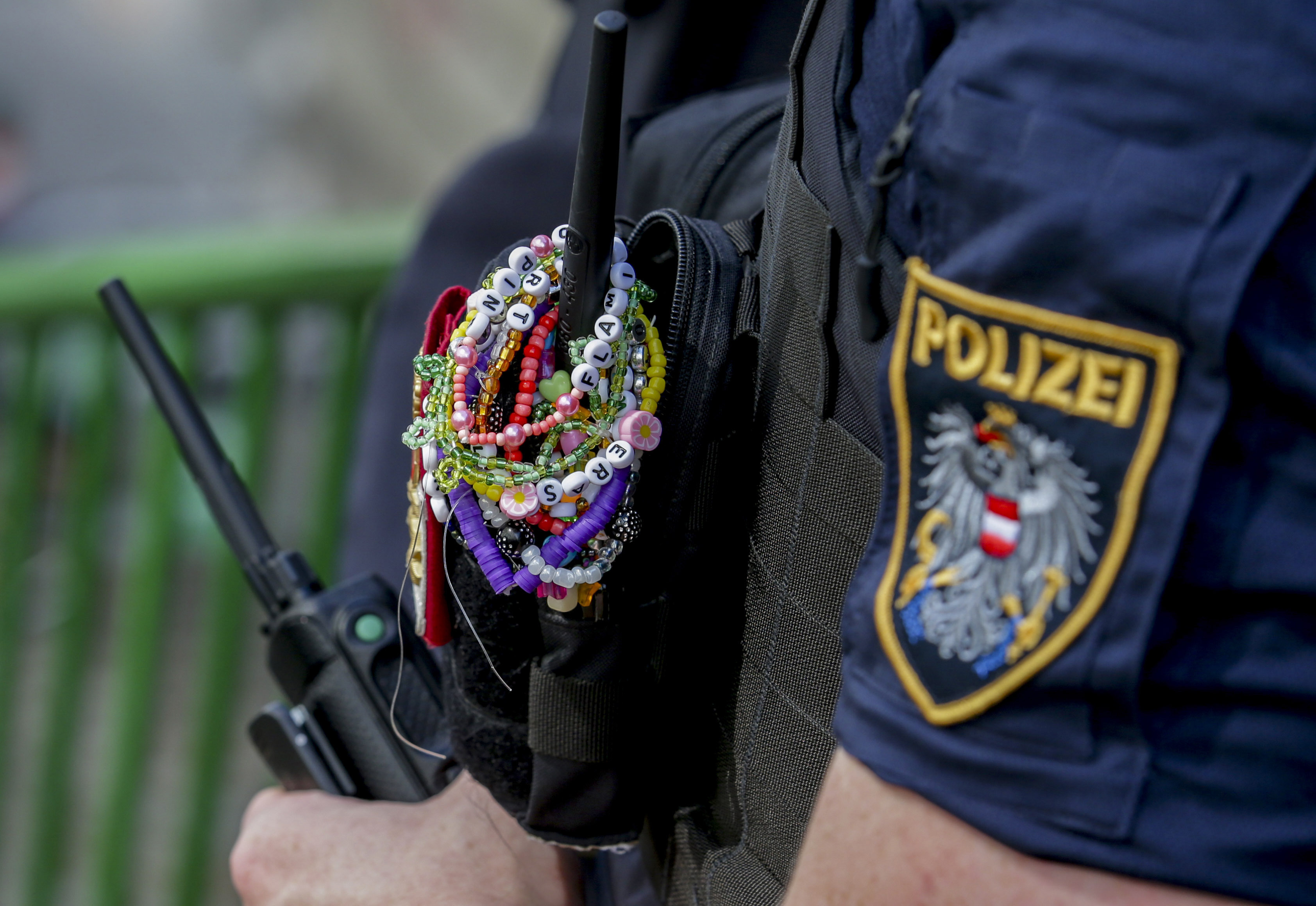 A police officer is decorated with Taylor Swift bracelets while guarding the city centre in Vienna on August 8, 2024. 