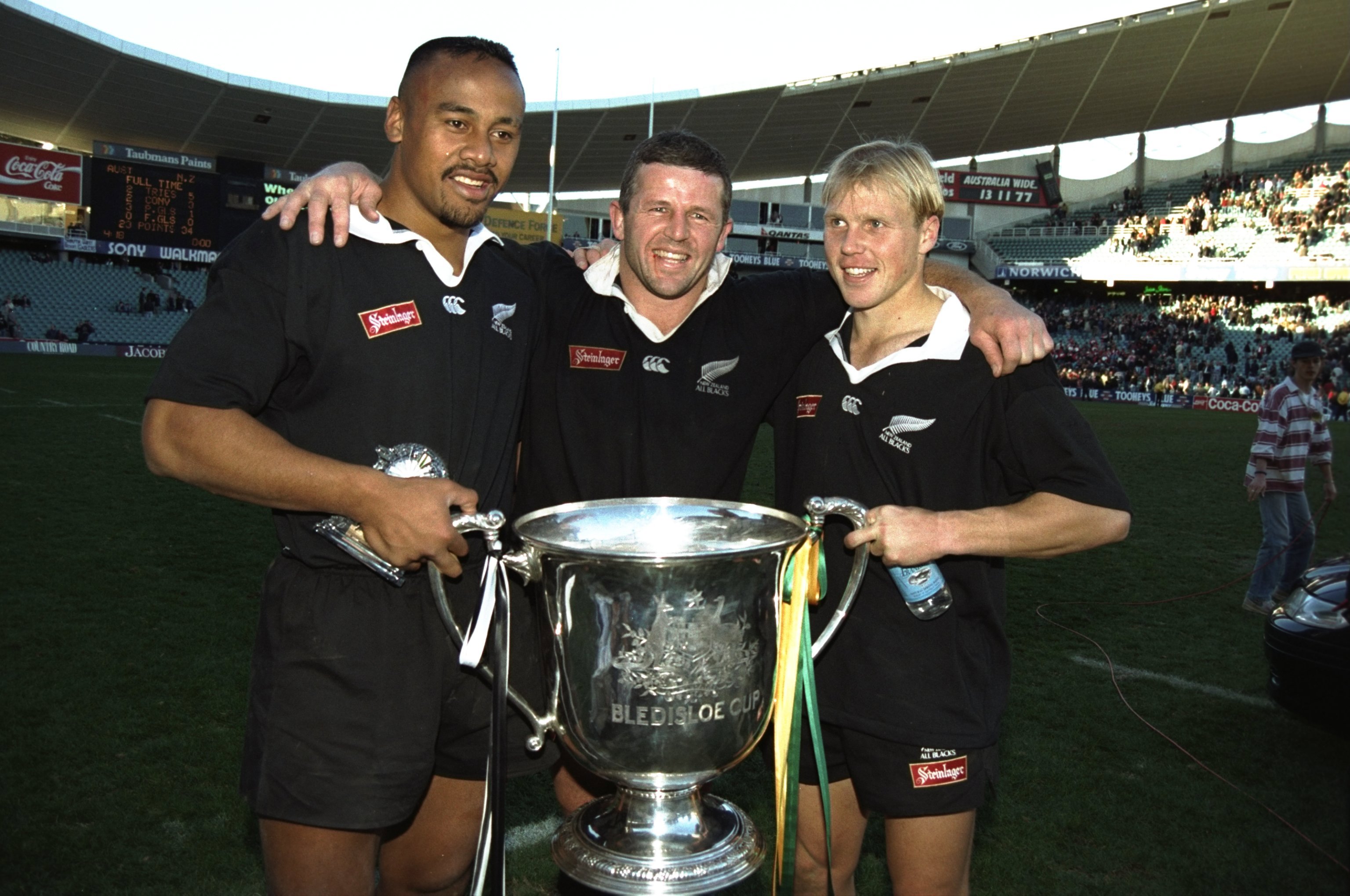 Jonah Lomu (left), Sean Fitzpatrick (centre) and Jeff Wilson (right) of New Zealand hold the Bledisloe Cup after winning the final against Australia in Sydney.