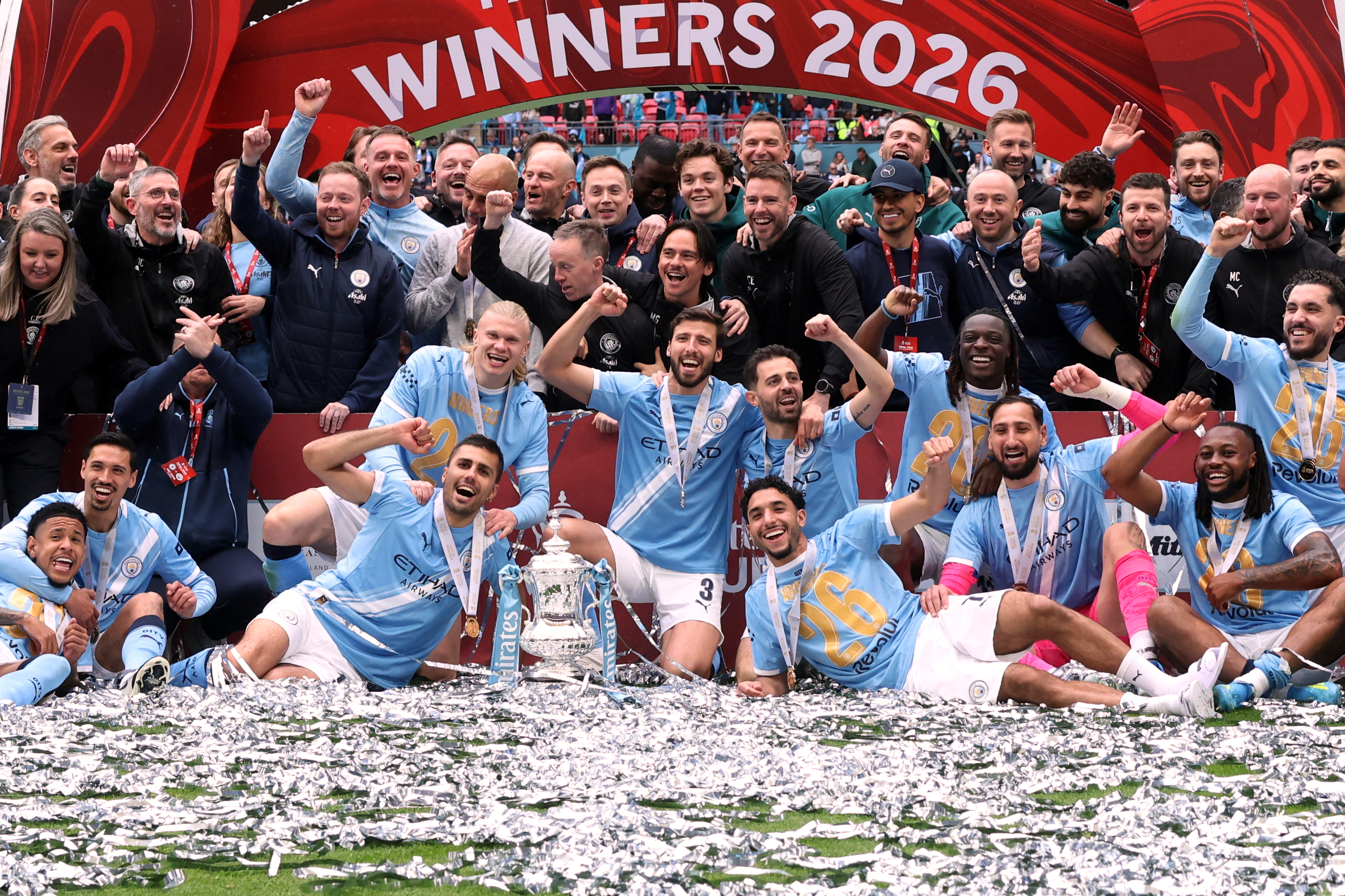 Manchester City players pose with the winner's trophy after the English FA Cup final soccer match between Chelsea and Manchester City in London, Saturday, May 16, 2026. (AP Photo/Richard Pelham)