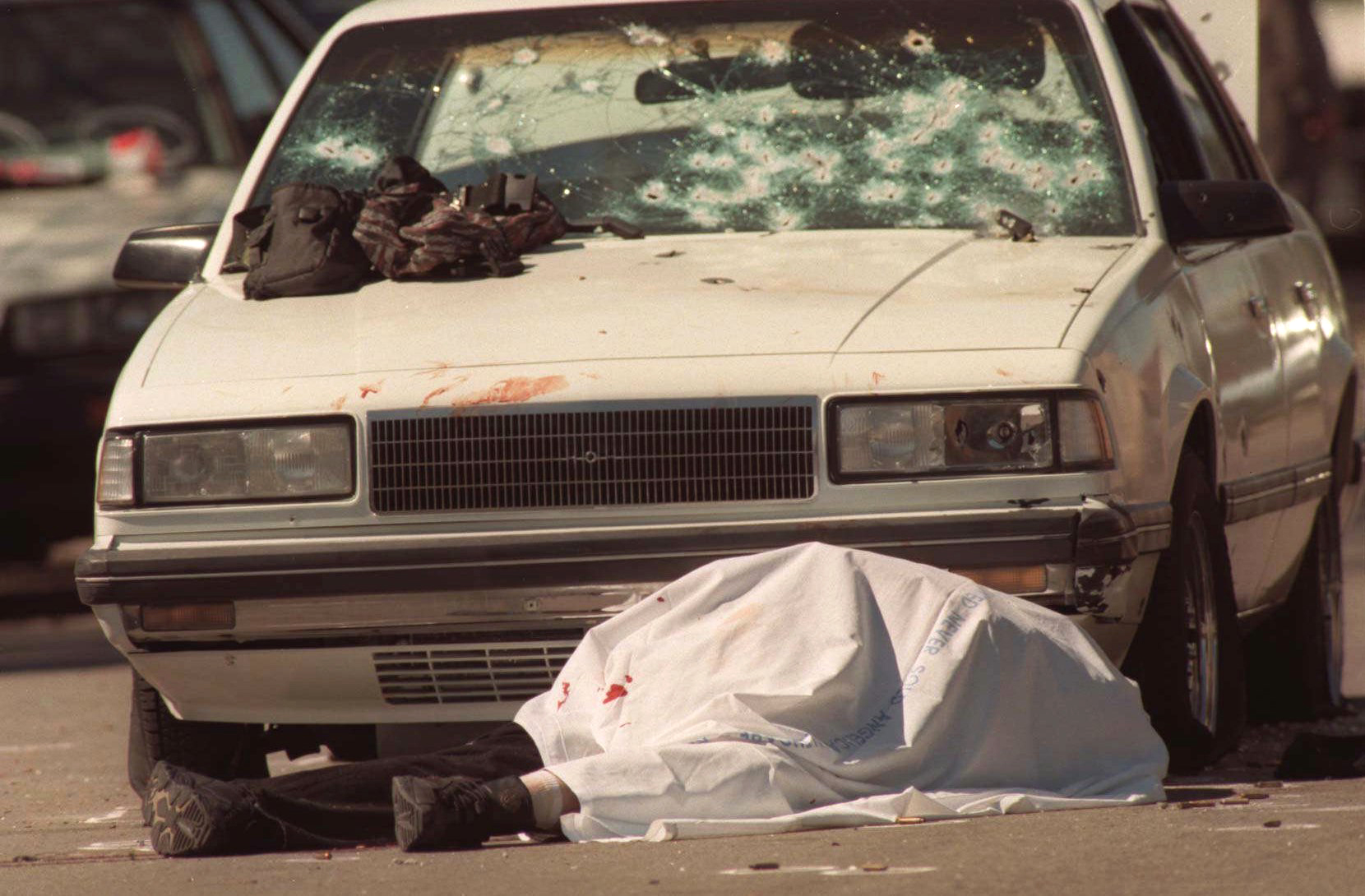 Emil Mătăsăreanu lies dead in front of a car peppered with bullet holes during a botched bank robbery and subsequent shootout in North Hollywood.
