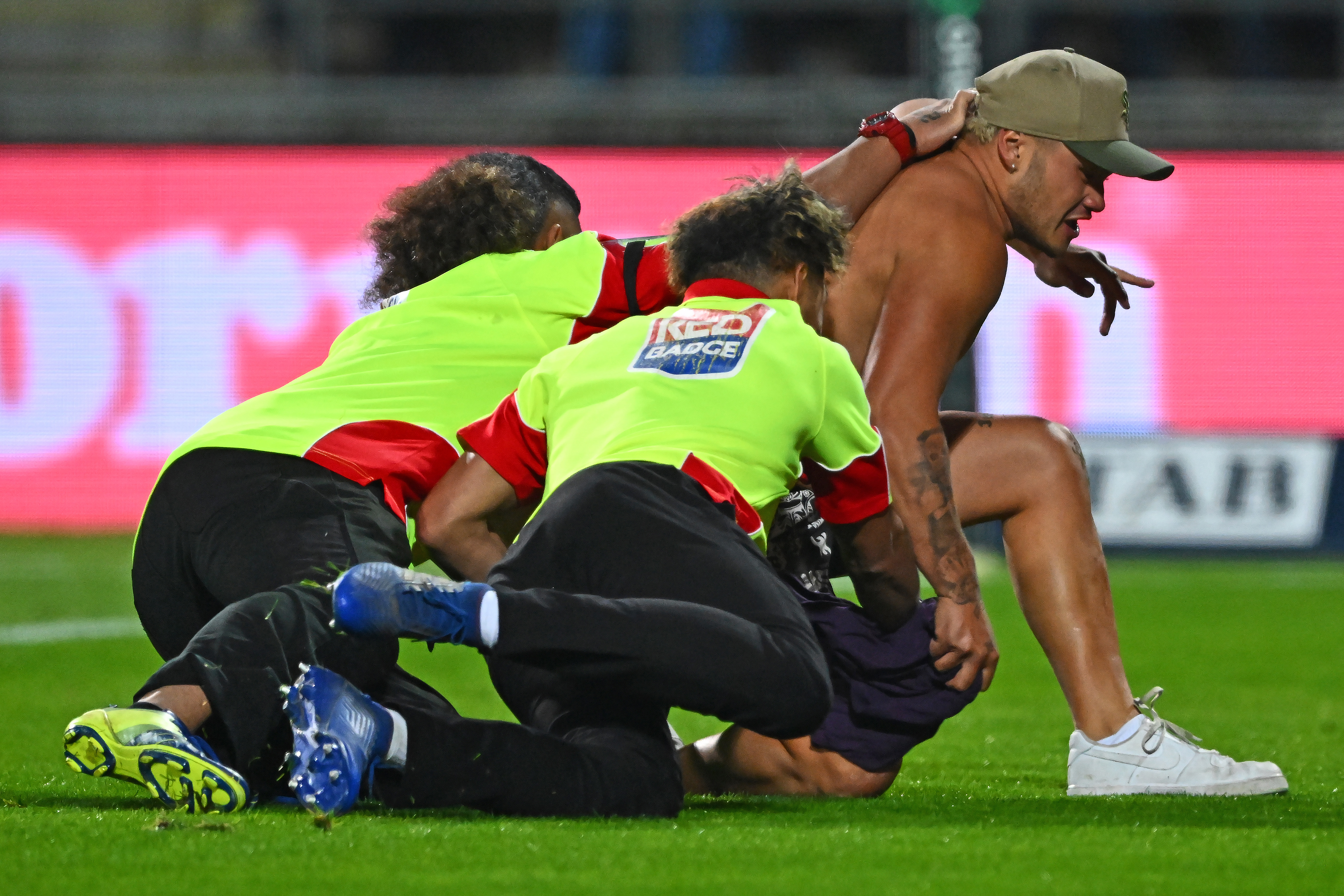 A pitch invader is tackled during the match between Warriors and Broncos at McLean Park in Napier.