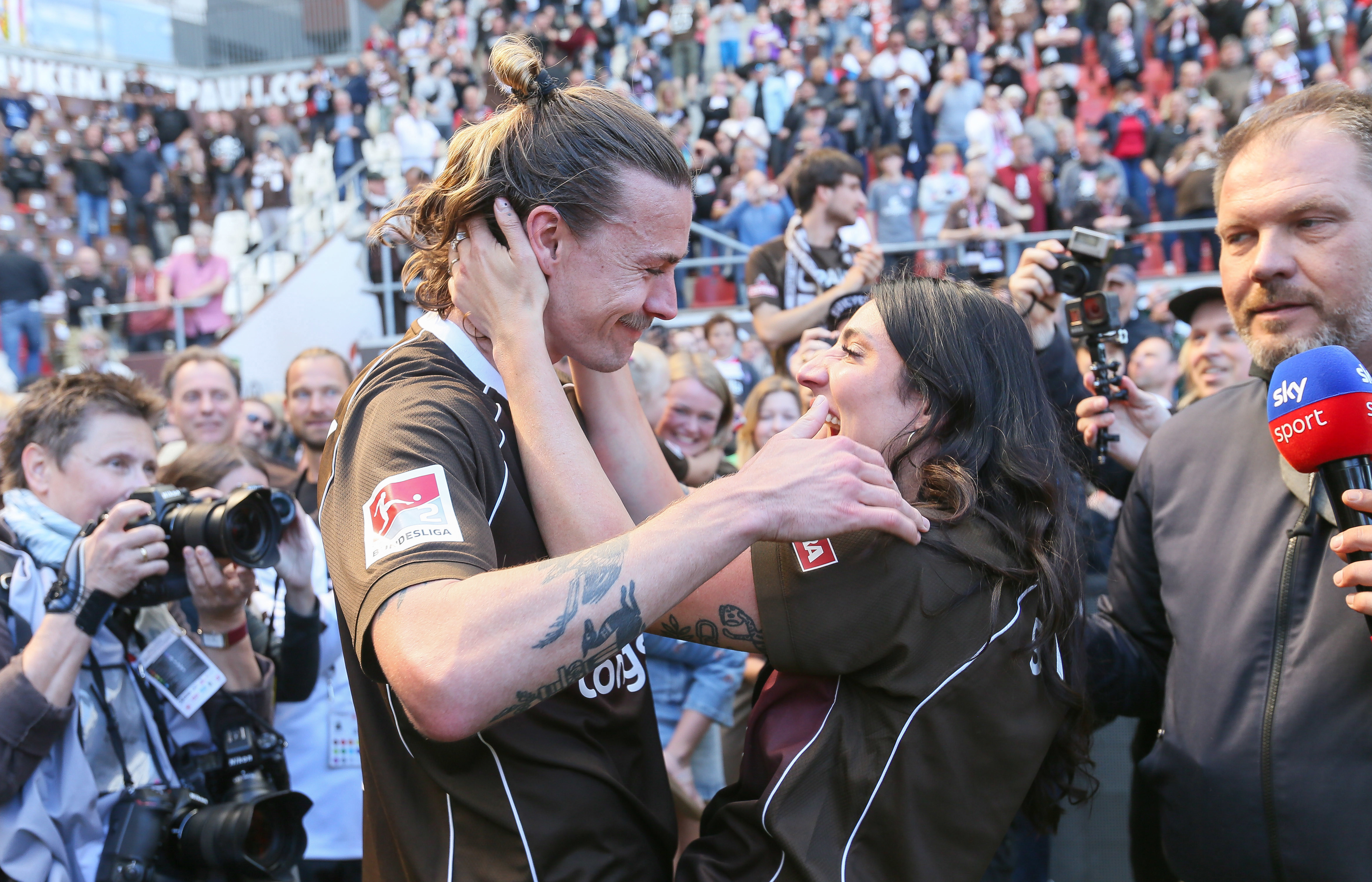 Jackson Irvine kisses Jemilla Pir following their promotion to the Bundesliga.