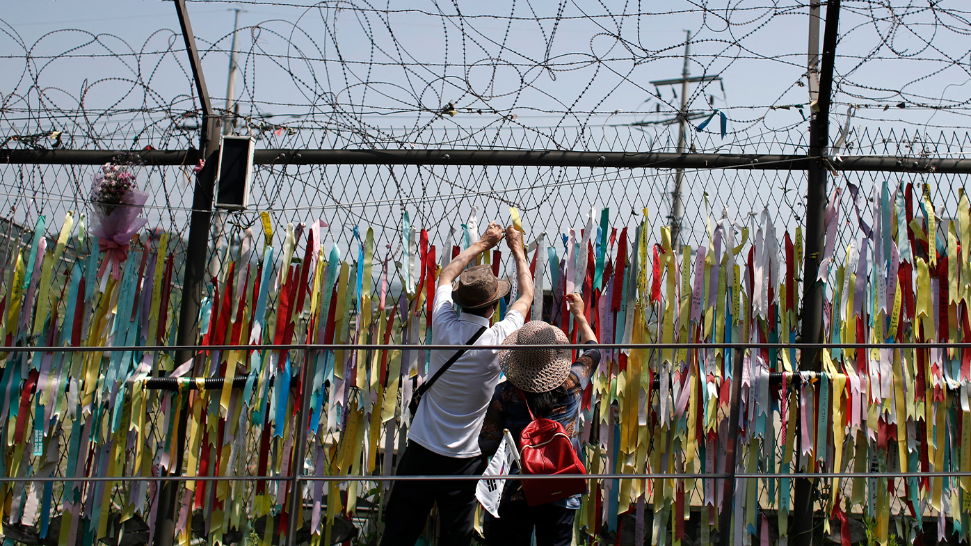 Visitors hang a ribbon on a wire fence decorated with other ribbons at the Imjingak Pavilion in Paju, South Korea, Tuesday, June 9, 2020. (AP Photo/Lee Jin-man)