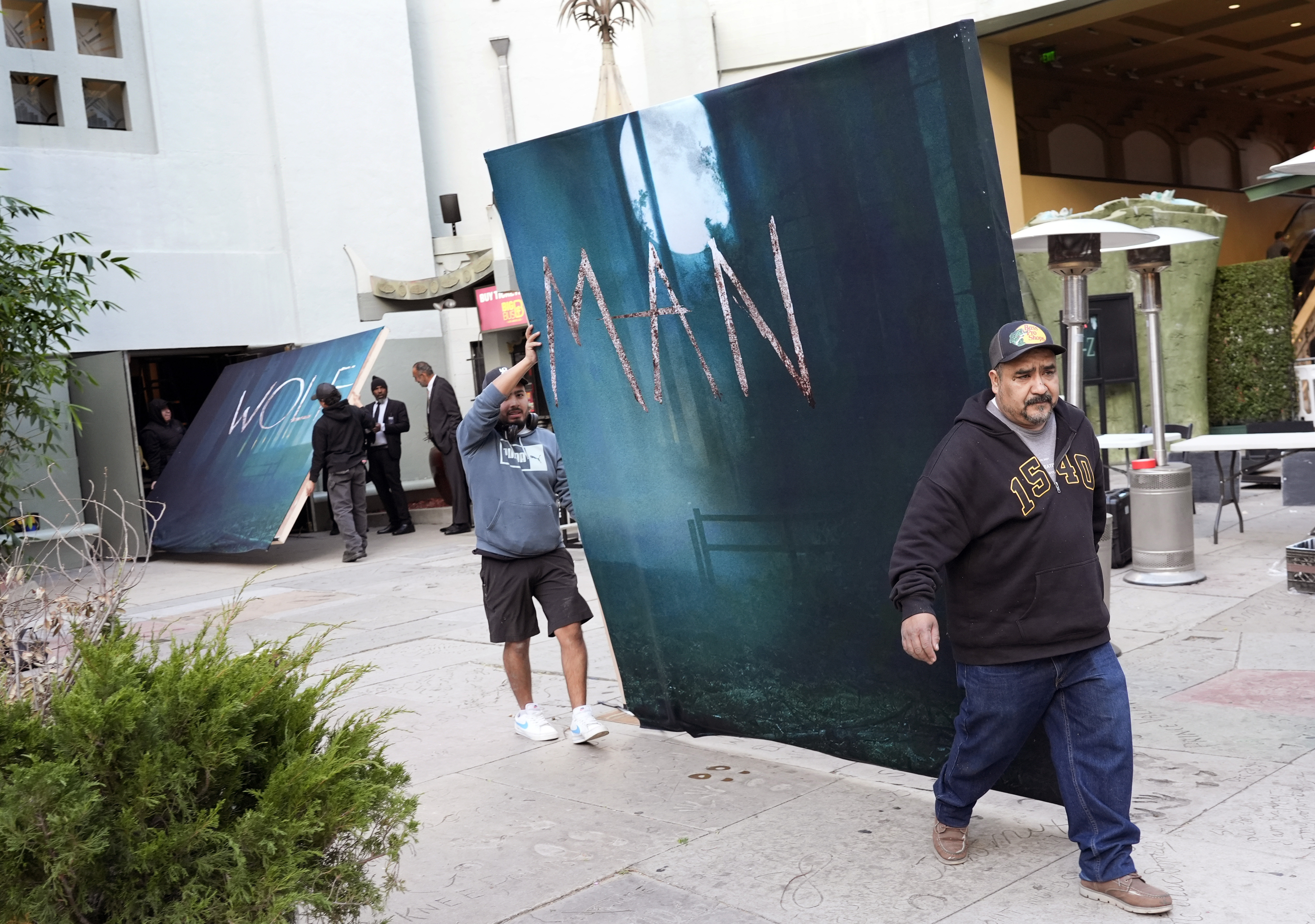 Crew members carry out signs for the new film "Wolf Man" after the premiere was cancelled