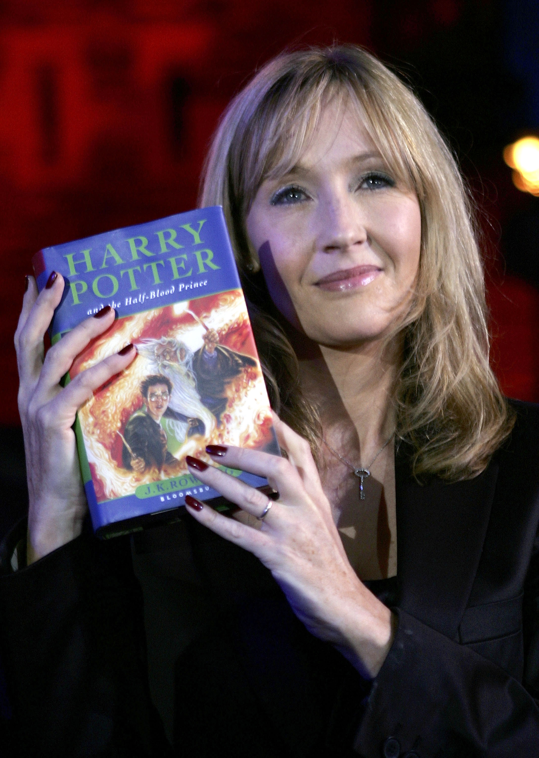 JK Rowling holding a Harry Potter book