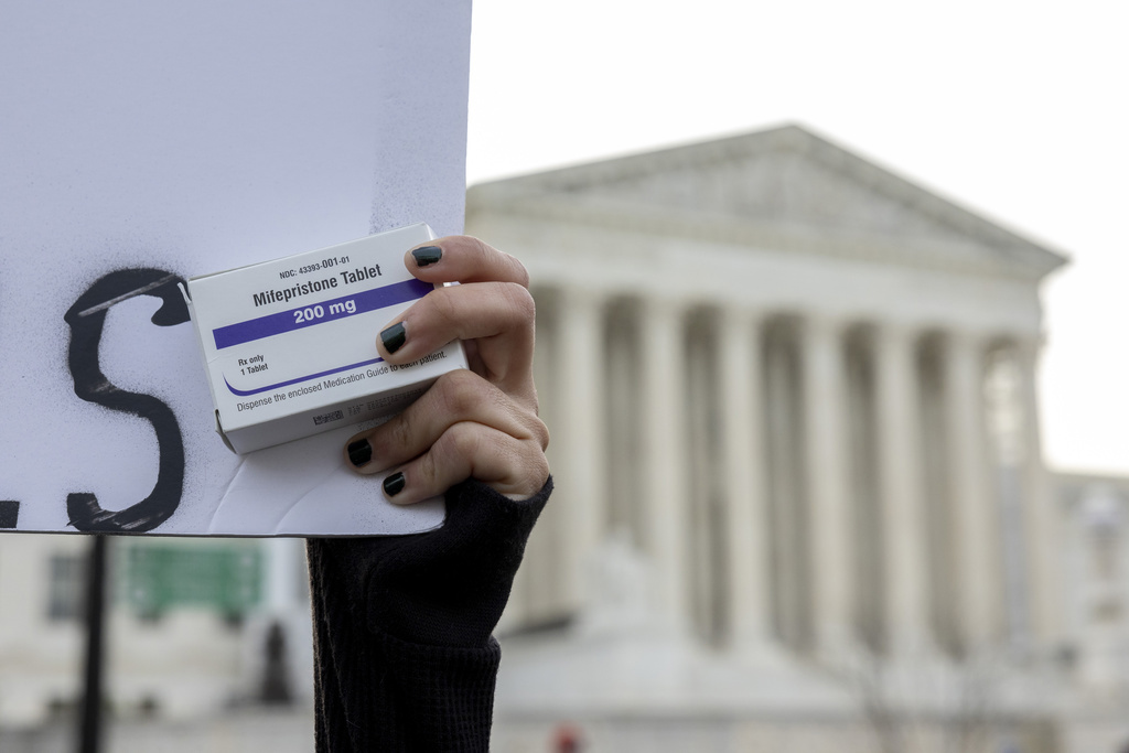 ARCHIVO - Una activista por el derecho al aborto sostiene una caja de pastillas de mifepristona mientras manifestantes de grupos antiaborto y por el derecho al aborto se concentran frente a la Corte Suprema en Washington, el martes 26 de marzo de 2024. (Foto AP/Amanda Andrade-Rhoades, Archivo )