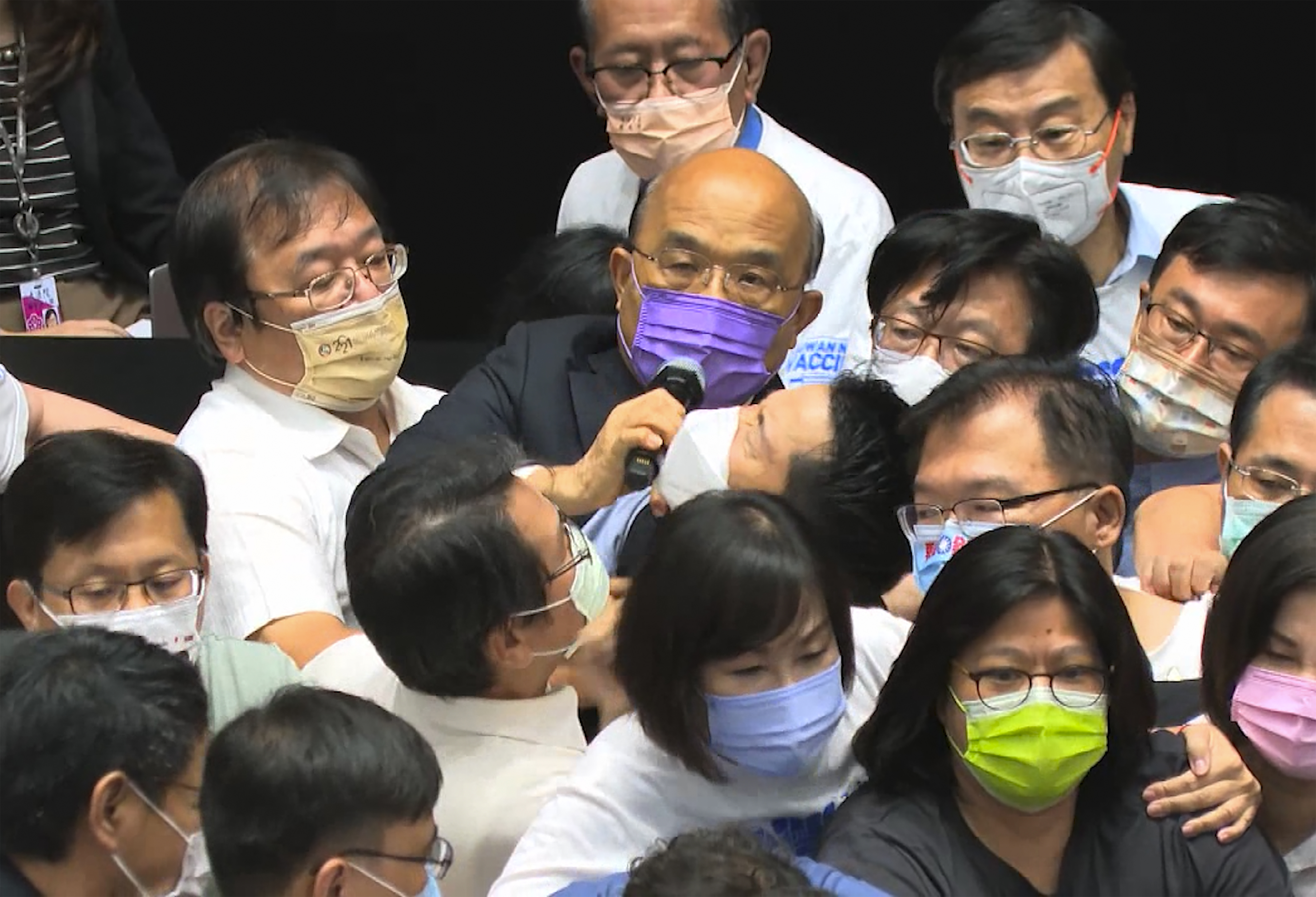 Premier Su Tseng-chang, in purple mask, tries to make a policy speech amid a scuffle between opposition Nationalist party and ruling Democratic Progressive Party lawmakers during a parliament session in Taipei. 