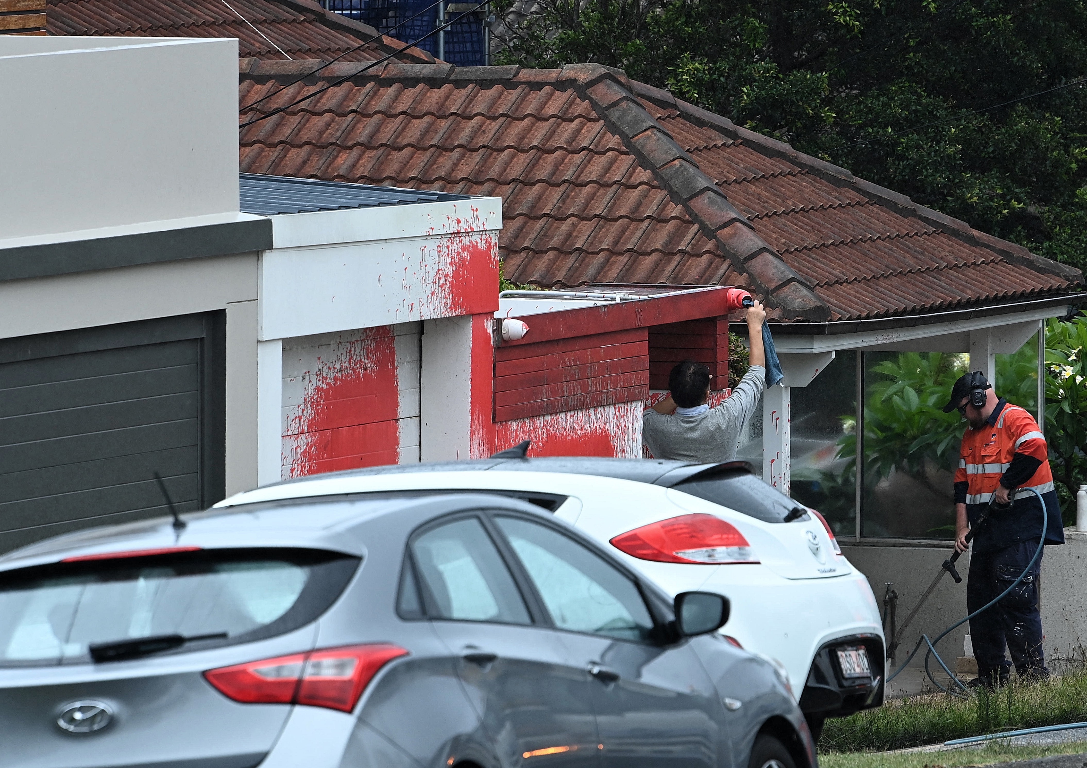 A man removes paint from a security camera from a home on Military Road at the scene of an antisemitic attack in Dover Heights NSW. January 17, 2025.