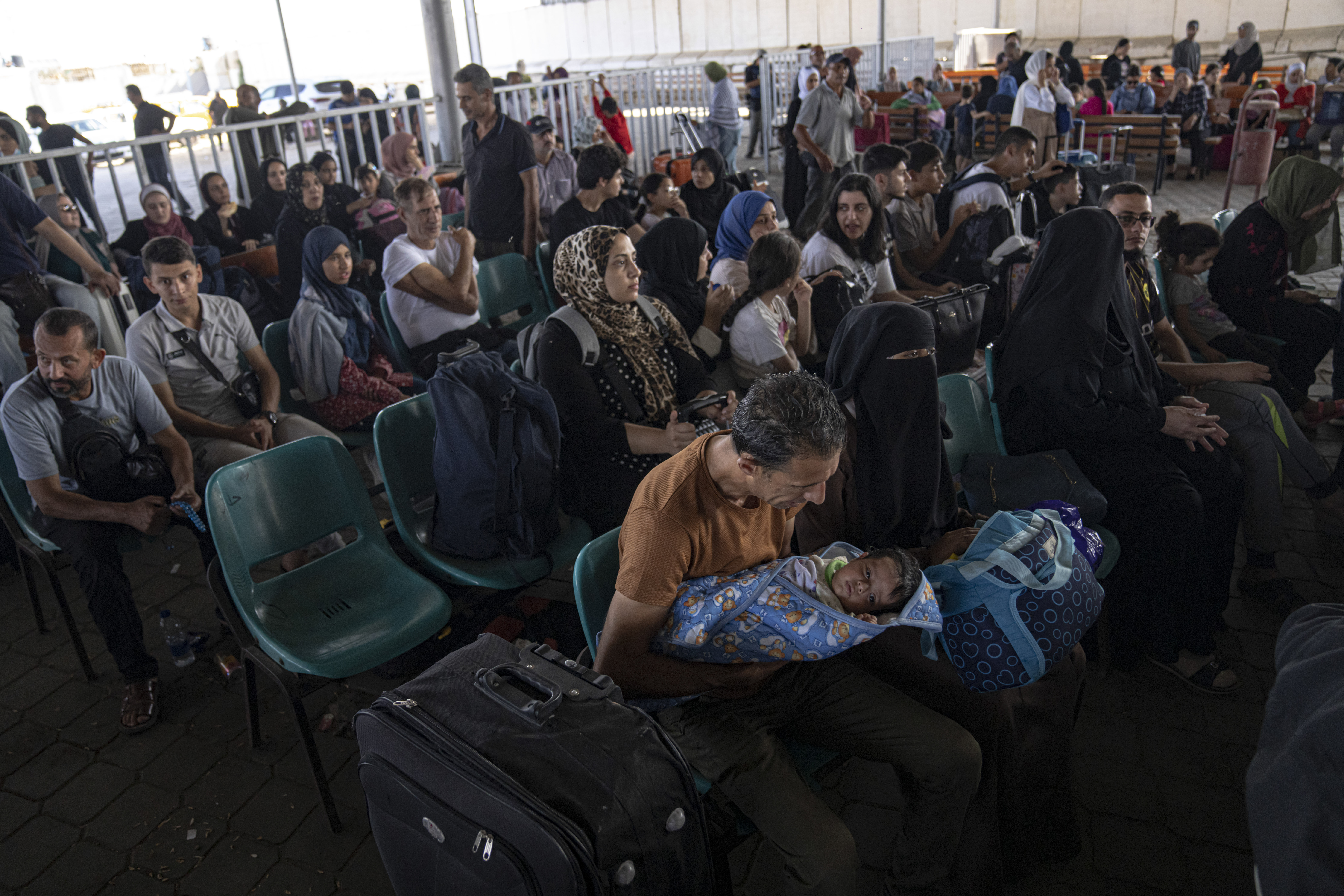 Palestinians wait to cross into Egypt at Rafah, Gaza Strip, on Wednesday, Nov. 1, 2023.  